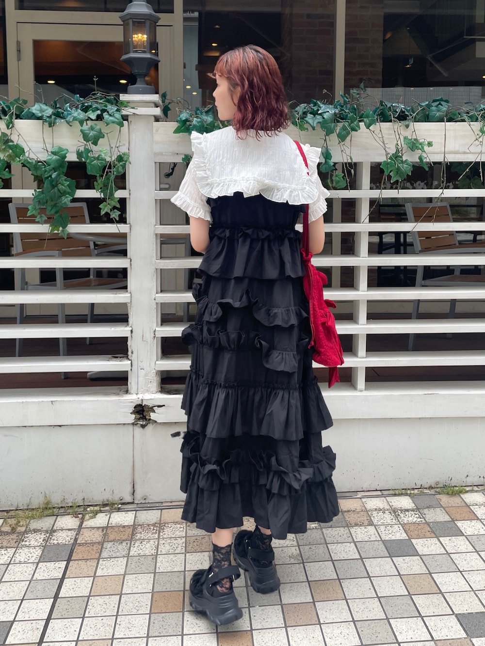 ブラック系のワンピース、ブラック系のサンダル、ホワイト系のシャツ/ブラウスを着用したレディースの夏コーディネートの7枚目の写真