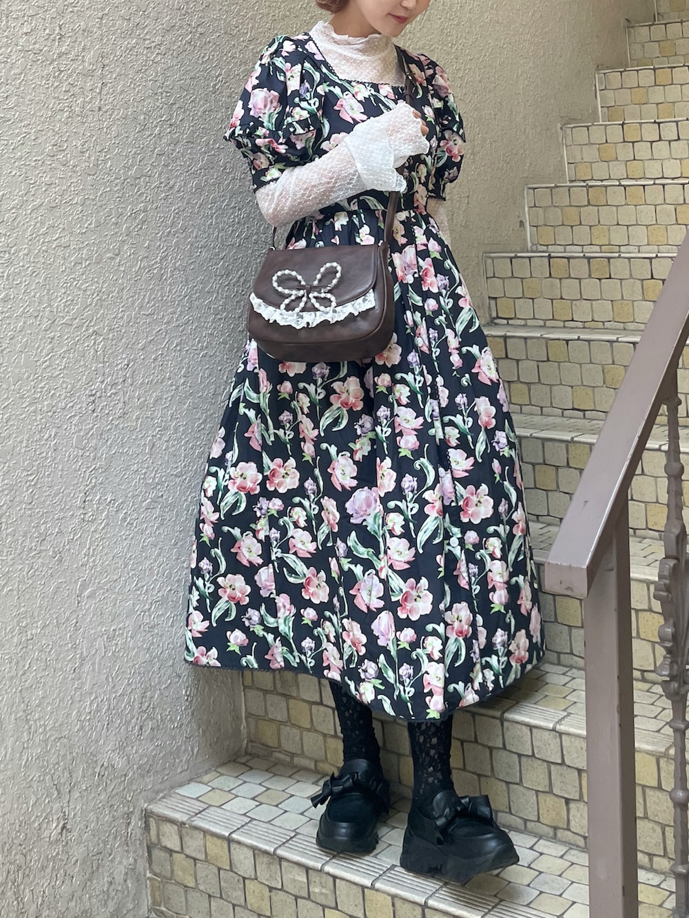 ブラック系のワンピース、ブラウン系のショルダーバッグ、ホワイト系のTシャツ/カットソーを着用したレディースの春コーディネートの2枚目の写真