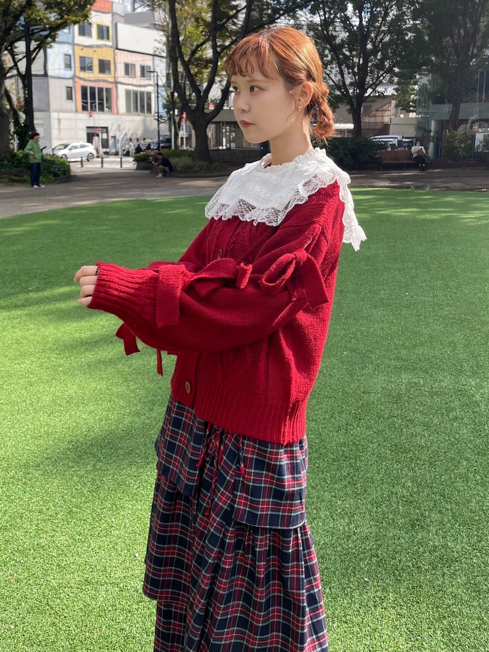 レッド系のカーディガン/ボレロ、ホワイト系のシャツ/ブラウス、ブルー系のスカートを着用したレディースの秋コーディネートの3枚目の写真