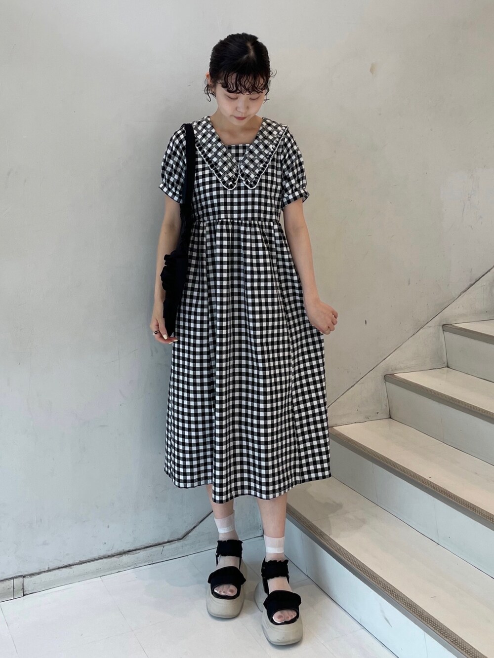 ブラック系のサンダル、ブラック系のワンピース、ブラック系のトートバッグを着用したレディースの夏コーディネートの2枚目の写真