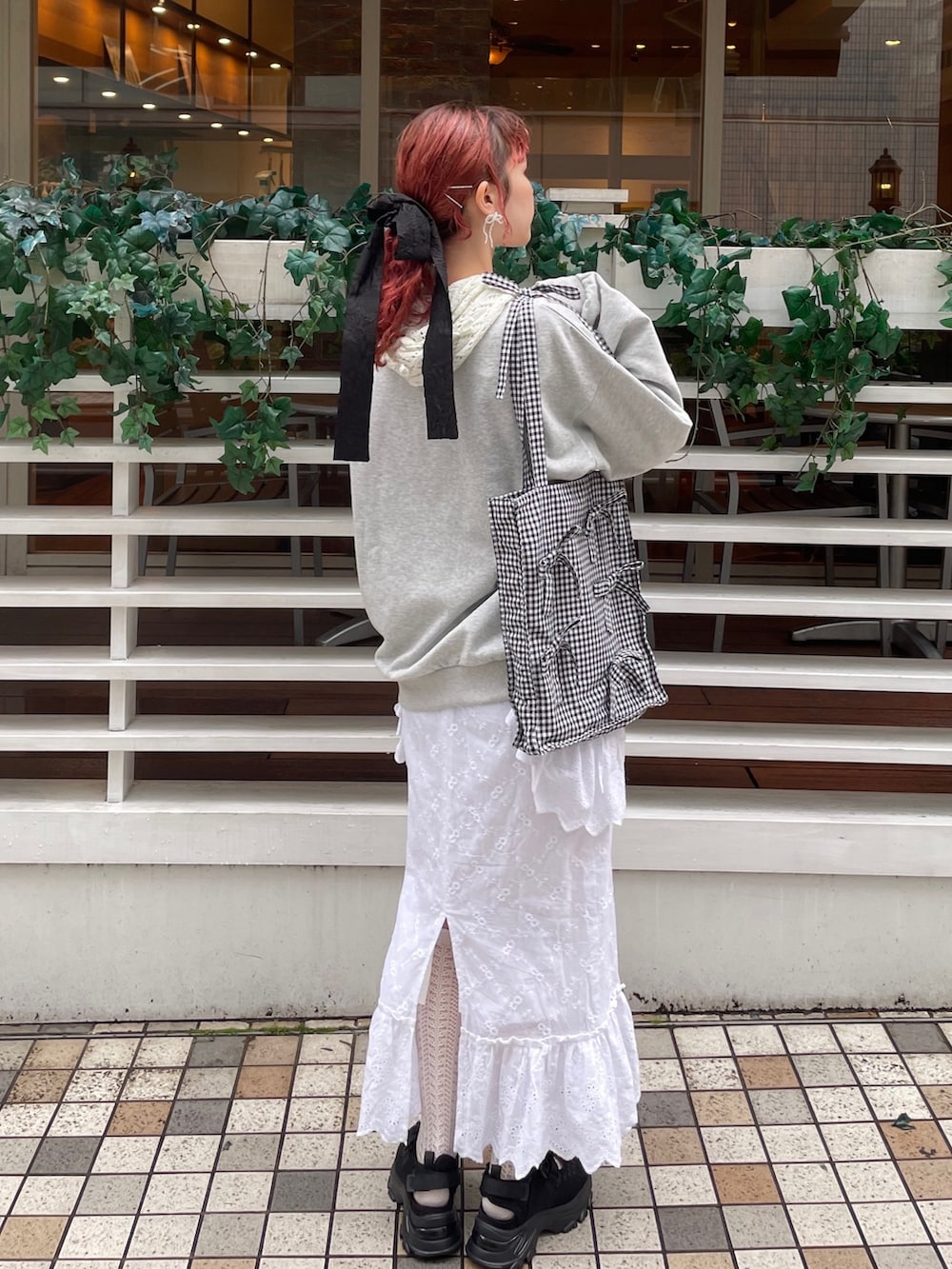 ブラック系のスニーカー、ブラック系のトートバッグ、グレー系のスウェットを着用したレディースの冬コーディネートの2枚目の写真