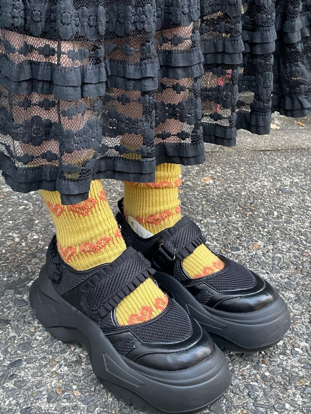 グレー系のスウェット、ブラック系のスカート、ブラック系のスニーカーを着用したレディースの冬コーディネートの5枚目の写真