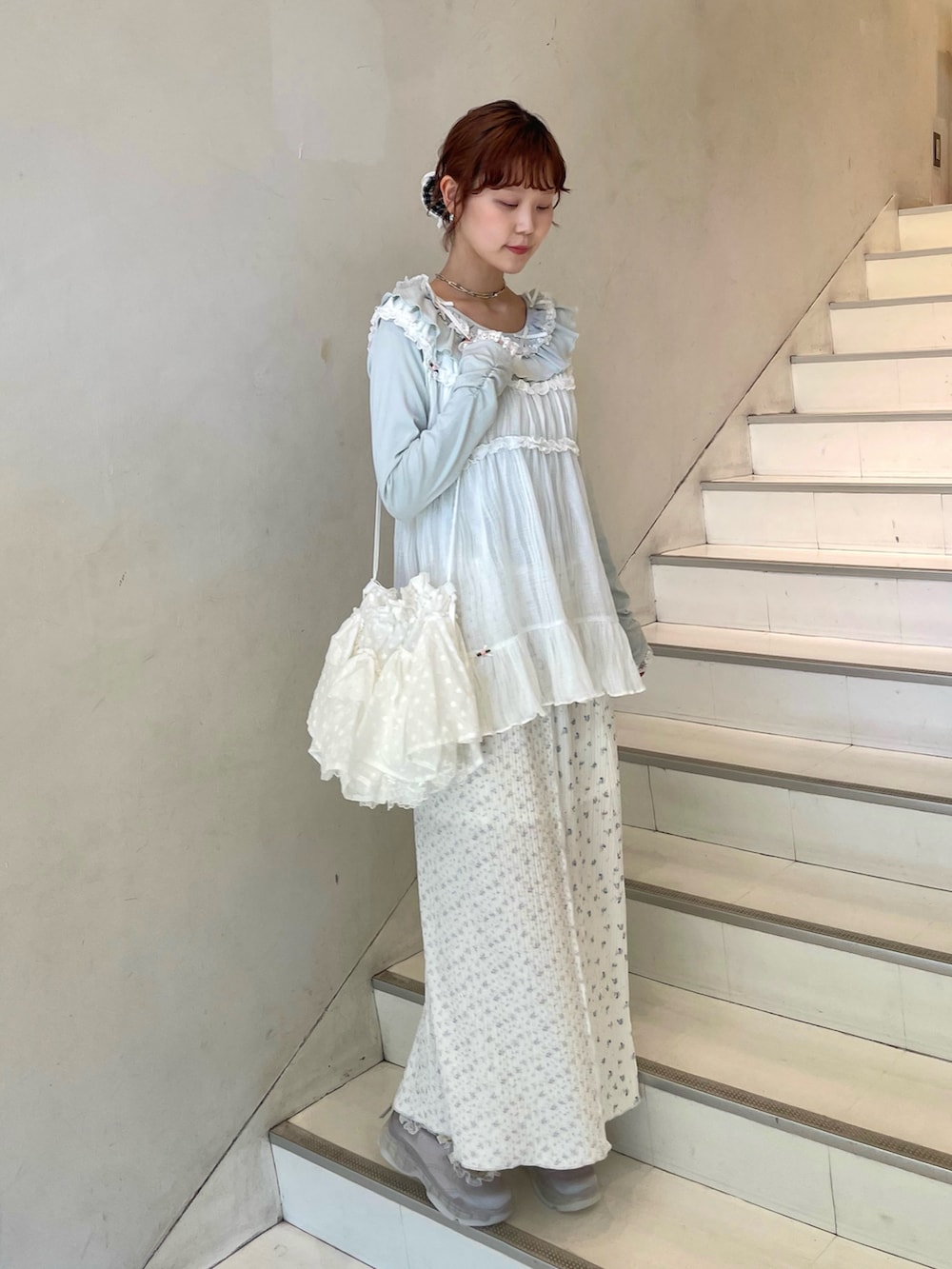 グリーン系のTシャツ/カットソー、ホワイト系のチュニック、ブルー系のスニーカーを着用したレディースの春コーディネートの2枚目の写真