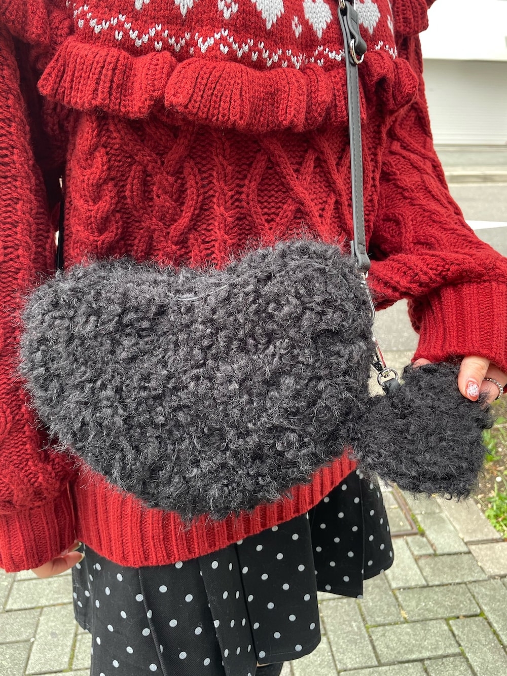 ブラック系のローファー、レッド系のニット/セーター、ブラック系のスカートを着用したレディースの秋コーディネートの6枚目の写真