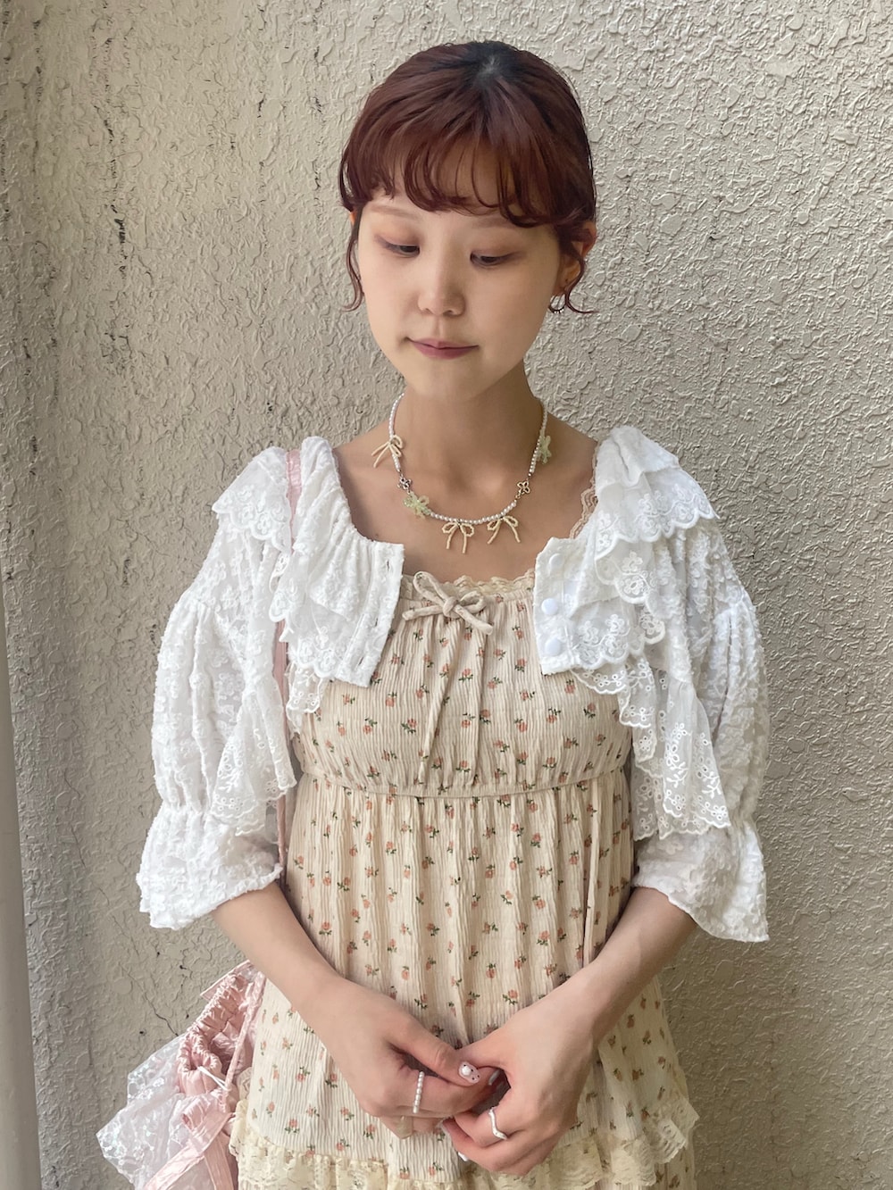 ベージュ系のワンピース、ホワイト系のカーディガン/ボレロ、ピンク系のショルダーバッグを着用したレディースの春コーディネートの6枚目の写真