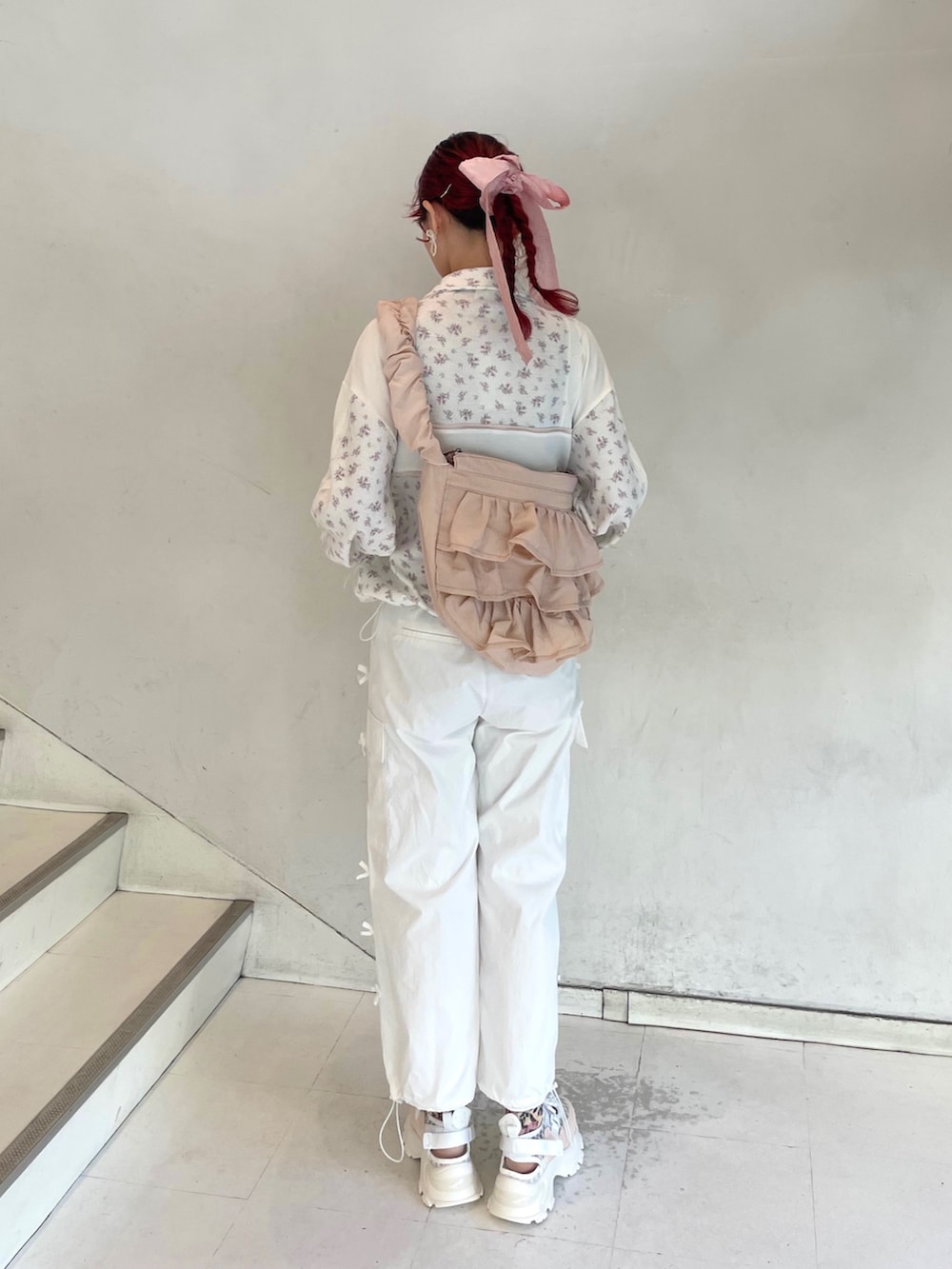 ピンク系のスニーカー、ピンク系のショルダーバッグ、ピンク系のジャージを着用したレディースの冬コーディネートの2枚目の写真