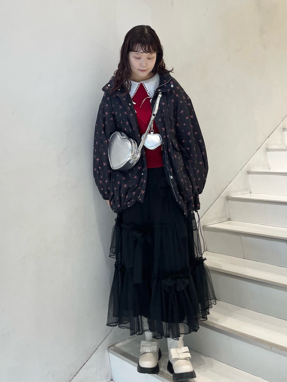 ブラック系のスカート、ホワイト系のシャツ/ブラウス、レッド系のニット/セーターを着用したレディースの冬コーディネートの2枚目の写真