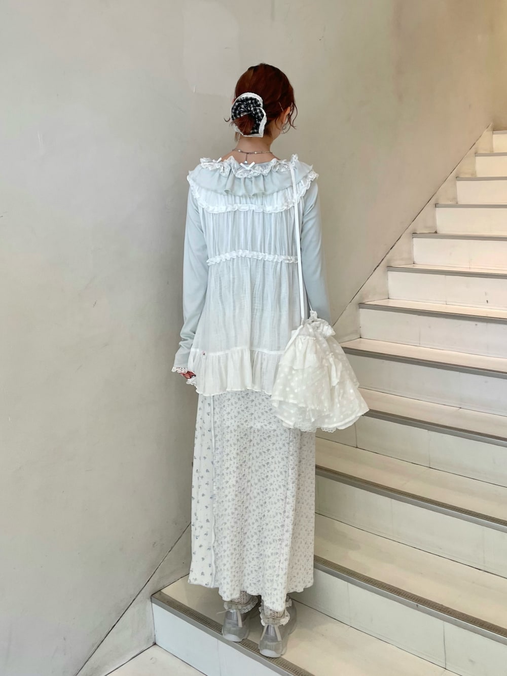 グリーン系のTシャツ/カットソー、ホワイト系のチュニック、ブルー系のスニーカーを着用したレディースの春コーディネートの3枚目の写真