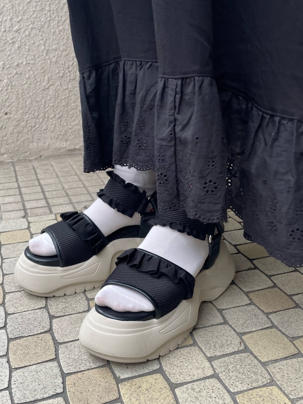 ブラック系のワンピース、ホワイト系のTシャツ/カットソー、ブラック系のサンダルを着用したレディースの夏コーディネートの5枚目の写真