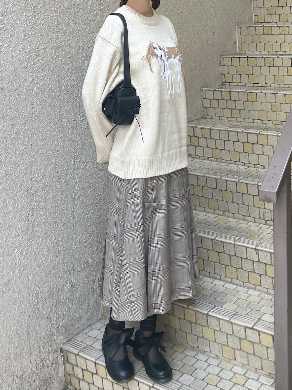 ホワイト系のニット/セーター、その他のスカート、ブラック系のショルダーバッグを着用したレディースの秋コーディネートの2枚目の写真