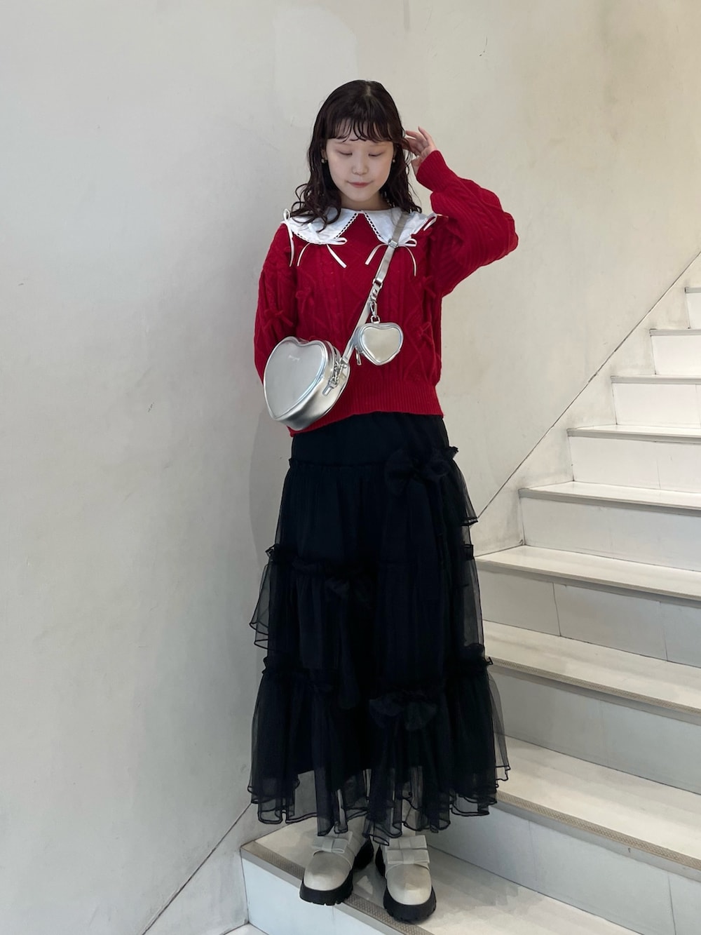 ブラック系のスカート、ホワイト系のシャツ/ブラウス、レッド系のニット/セーターを着用したレディースの冬コーディネートの5枚目の写真