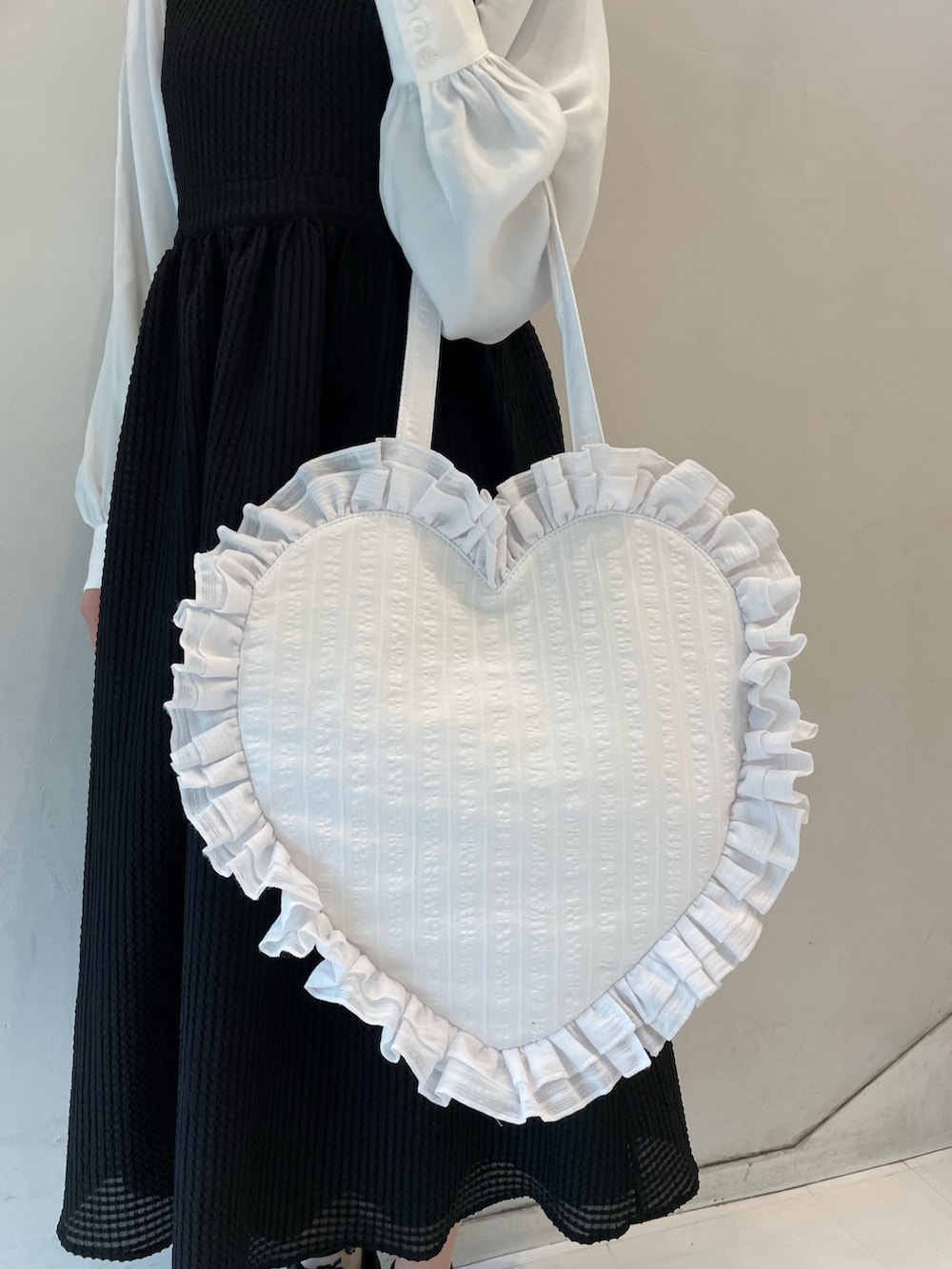 ブラック系のワンピース、ホワイト系のトートバッグ、ブラック系のスニーカーを着用したレディースの春コーディネートの8枚目の写真