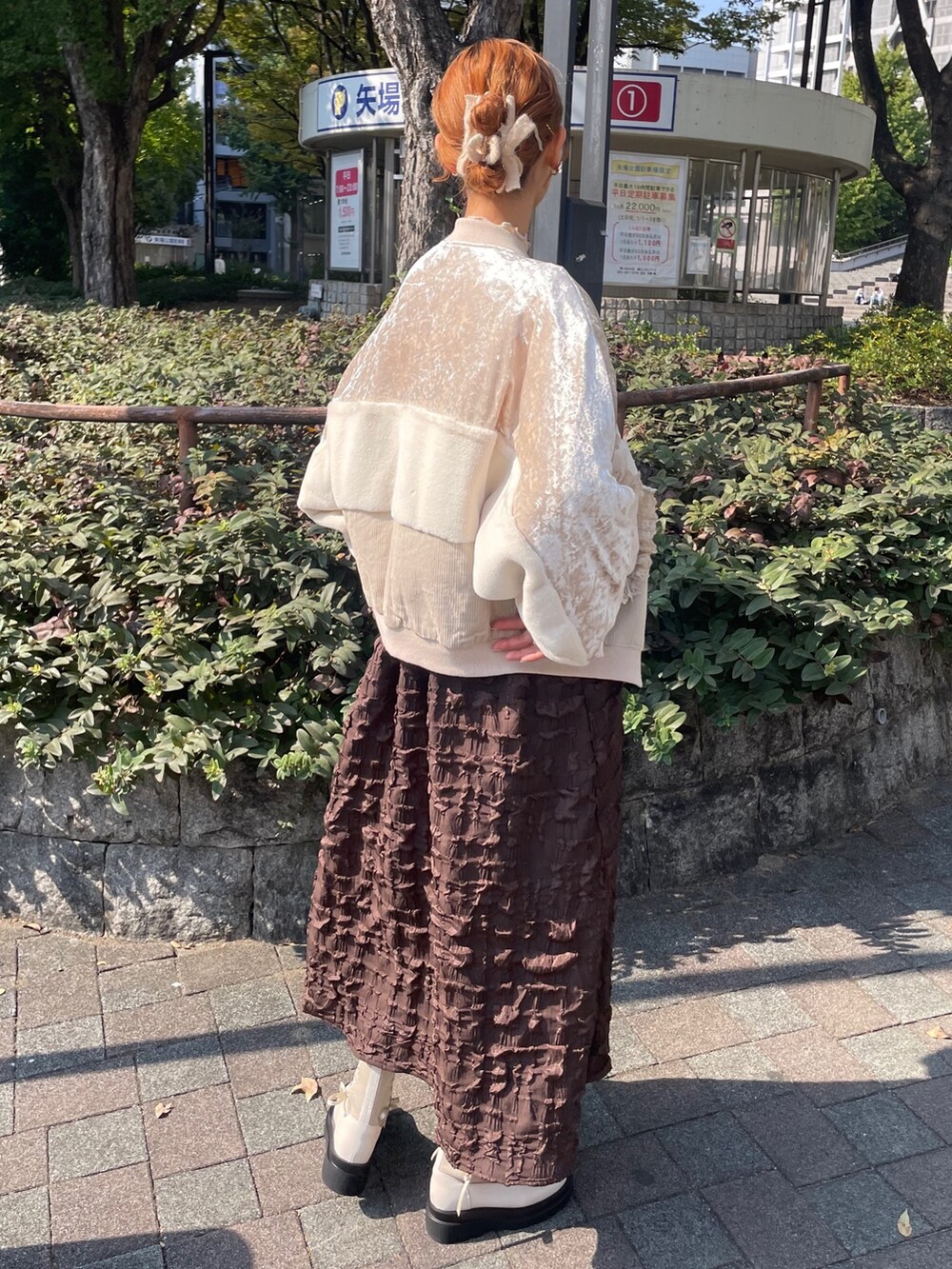 ブラウン系のワンピース、ホワイト系のブルゾン、イエロー系のニット/セーターを着用したレディースの秋コーディネートの3枚目の写真