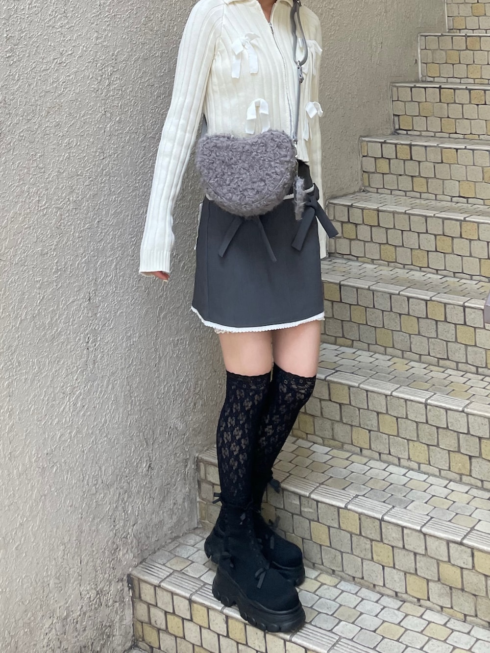 ホワイト系のカーディガン/ボレロ、グレー系のスカート、グレー系のショルダーバッグを着用したレディースの秋コーディネートの3枚目の写真