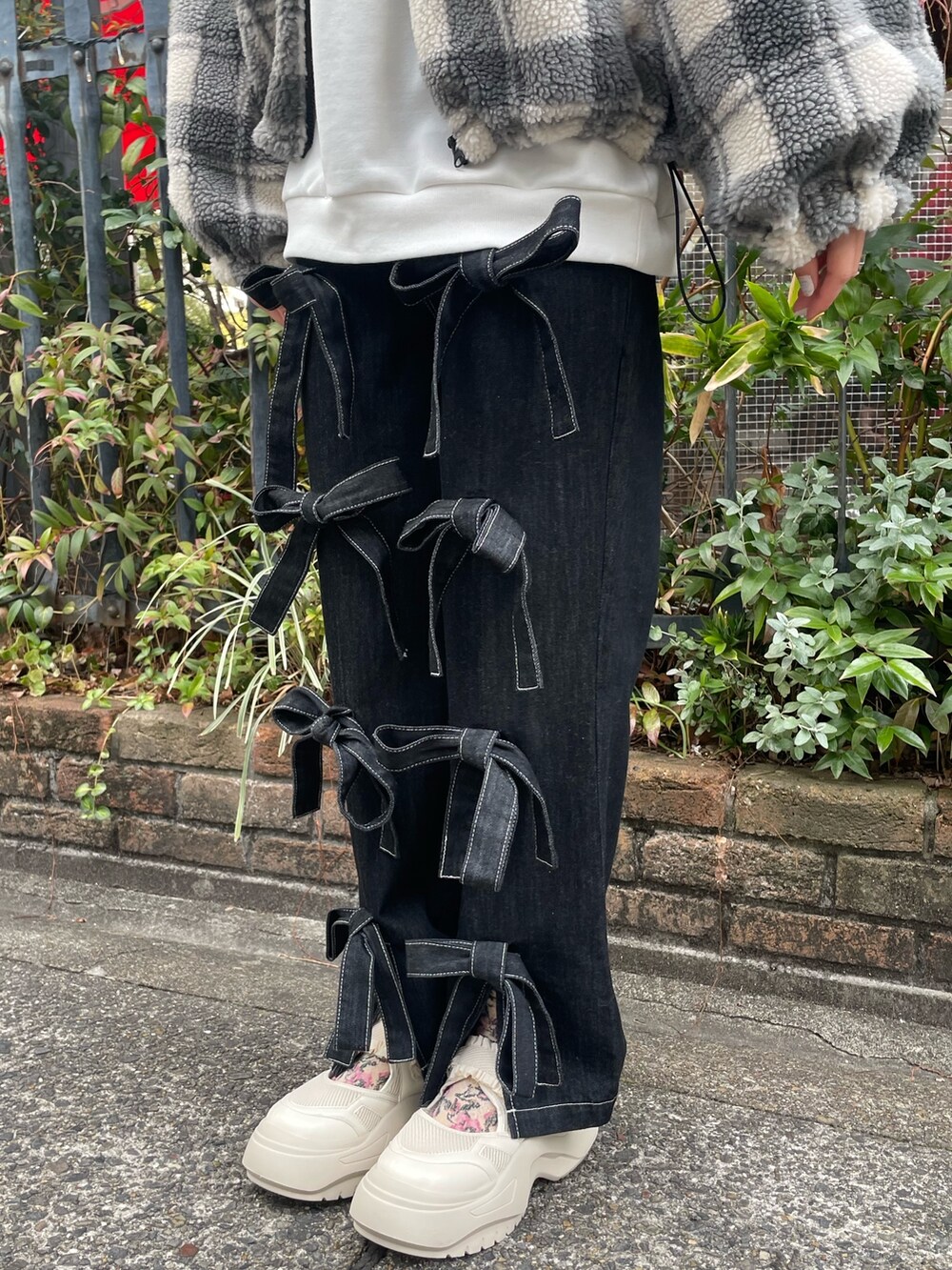 ブラック系のデニムパンツ、ホワイト系のスニーカー、ホワイト系のスウェットを着用したレディースの冬コーディネートの4枚目の写真