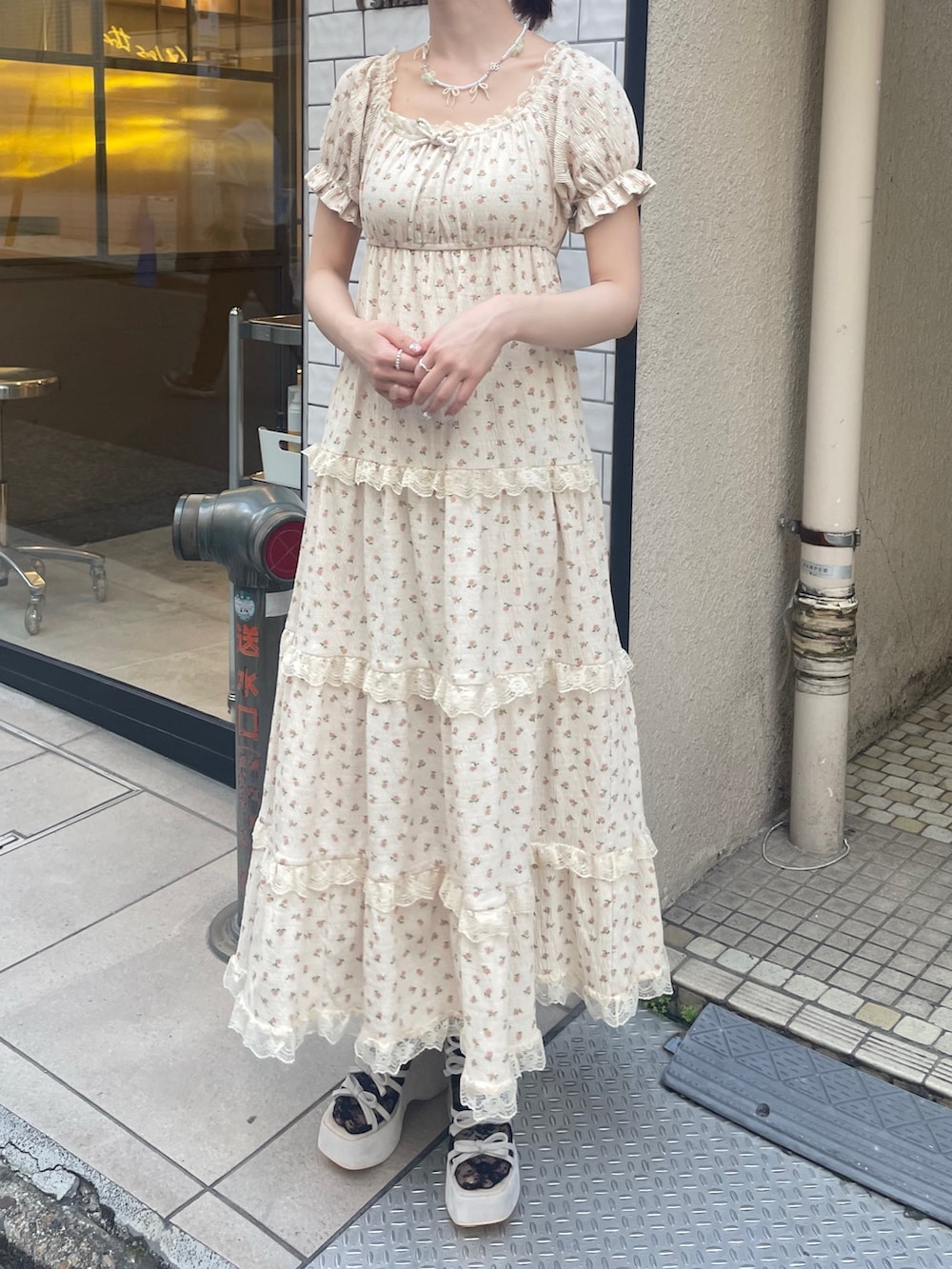 ベージュ系のワンピース、ホワイト系のカーディガン/ボレロ、ピンク系のショルダーバッグを着用したレディースの春コーディネートの5枚目の写真