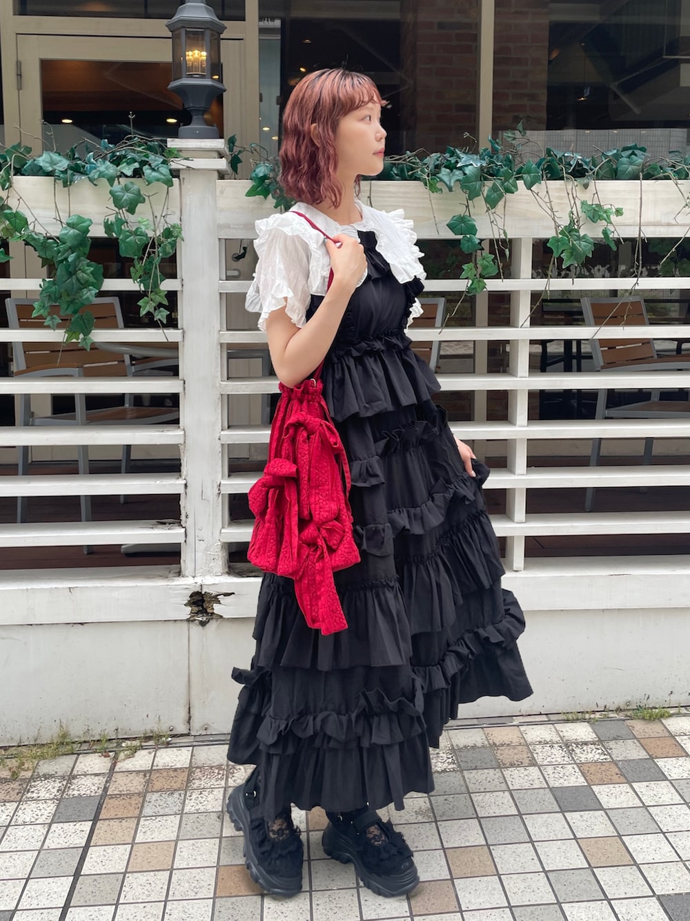 ブラック系のワンピース、ブラック系のサンダル、ホワイト系のシャツ/ブラウスを着用したレディースの夏コーディネートの3枚目の写真