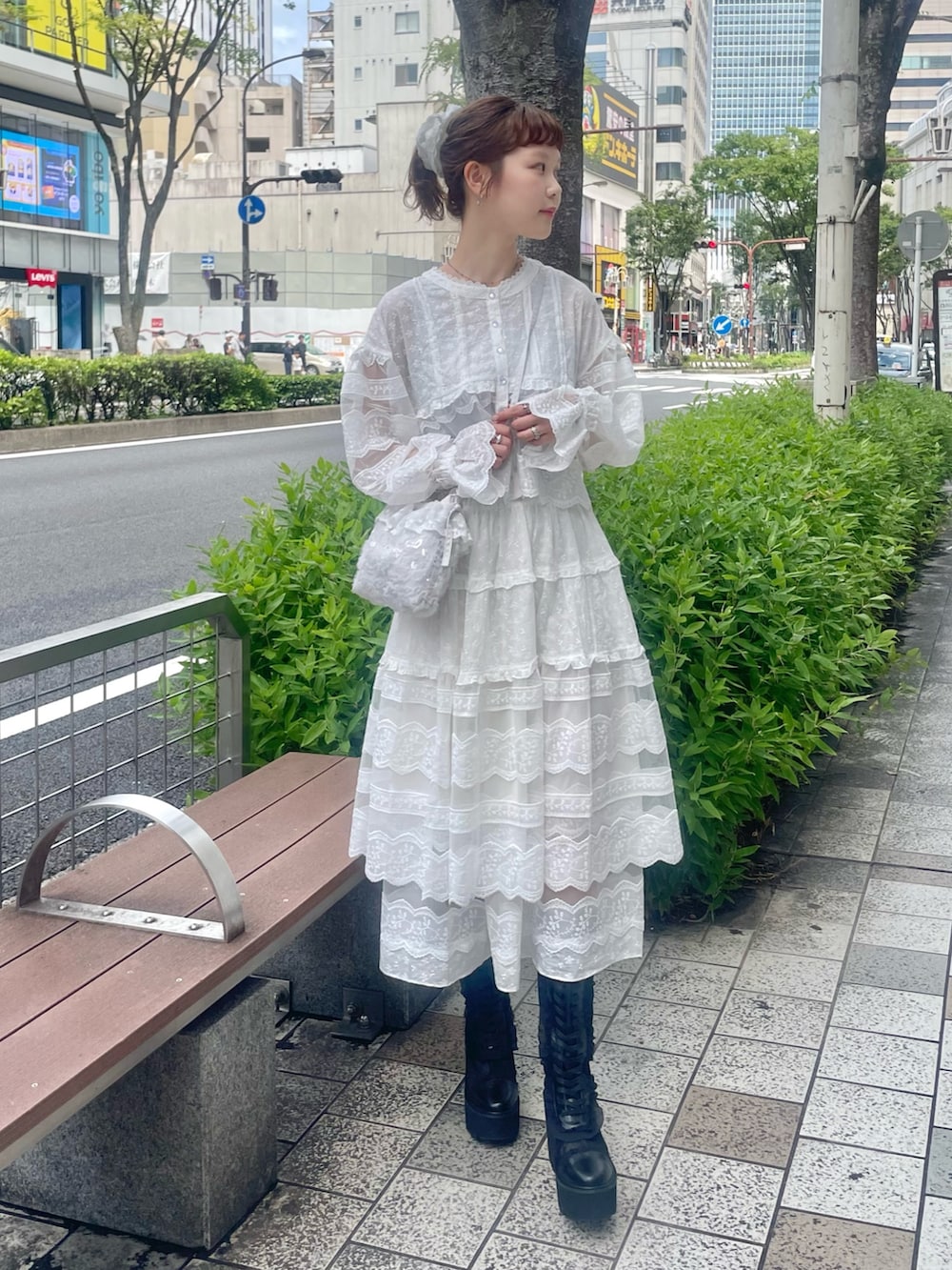 ホワイト系のシャツ/ブラウス、ホワイト系のスカート、ホワイト系のハンドバッグを着用したレディースの夏コーディネートの2枚目の写真