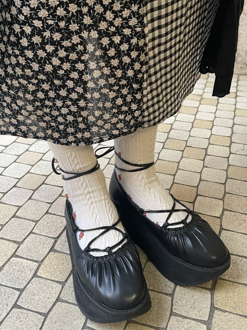 ブラック系のトレンチコート、ブラック系のワンピース、ブラック系のバレエシューズを着用したレディースの春コーディネートの6枚目の写真