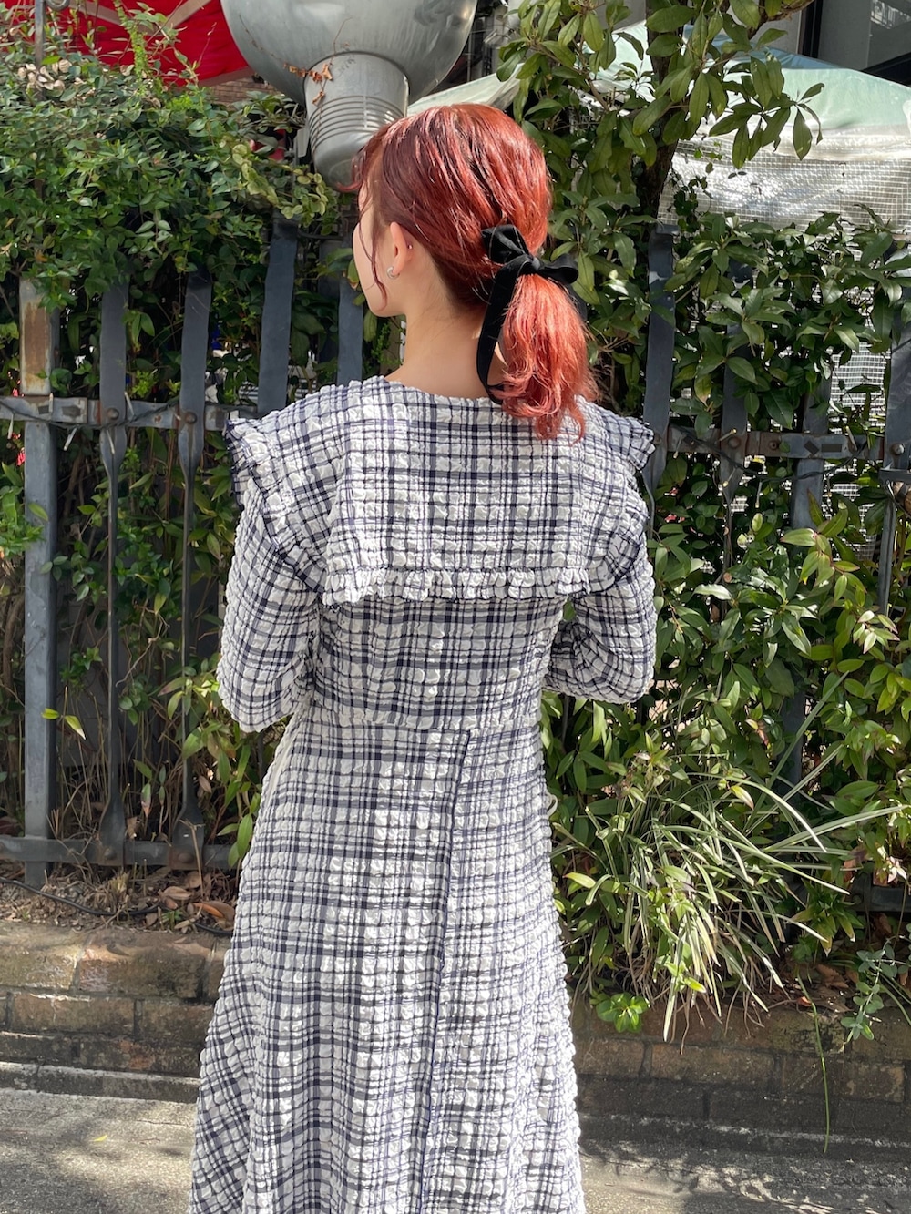 ブルー系のワンピース、ブラック系のパンプスを着用したレディースの春コーディネートの5枚目の写真