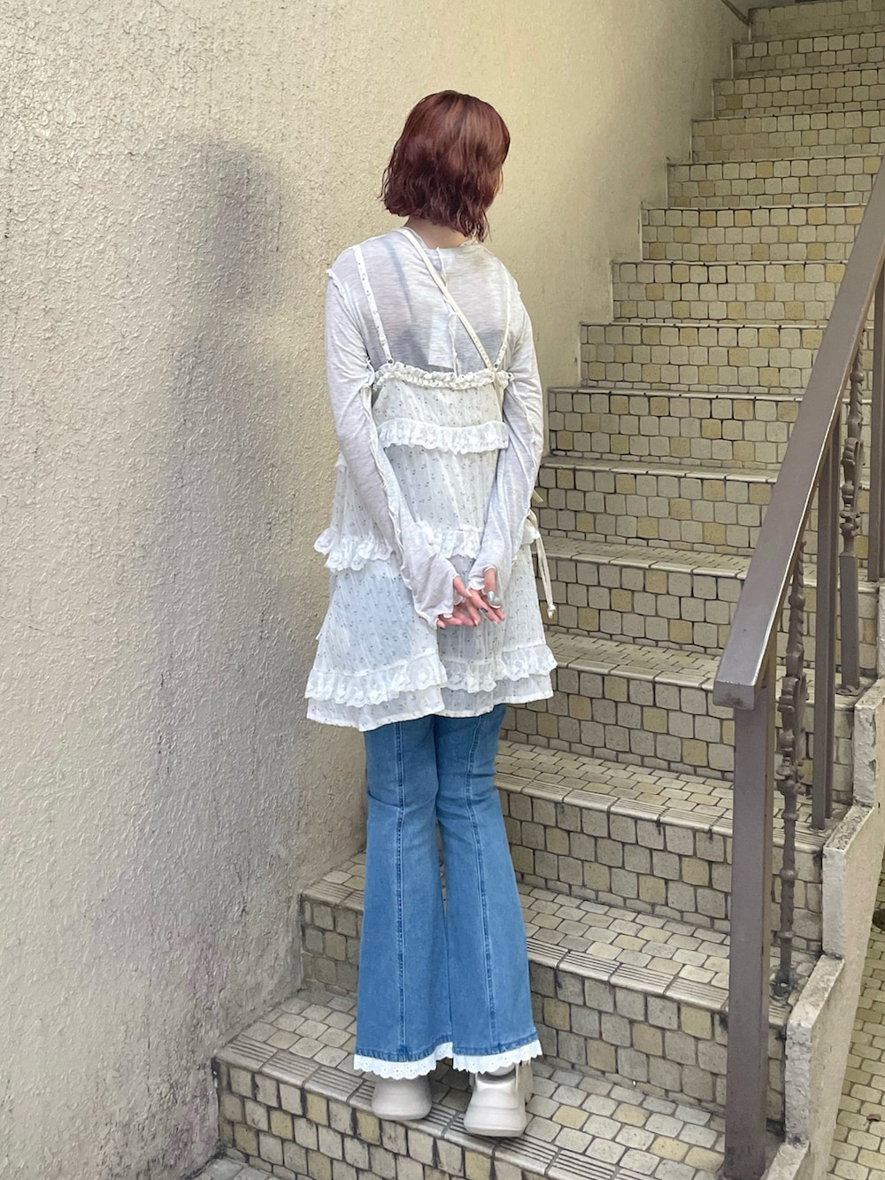 ブルー系のデニムパンツ、グレー系のTシャツ/カットソー、ホワイト系のサンダルを着用したレディースの夏コーディネートの5枚目の写真