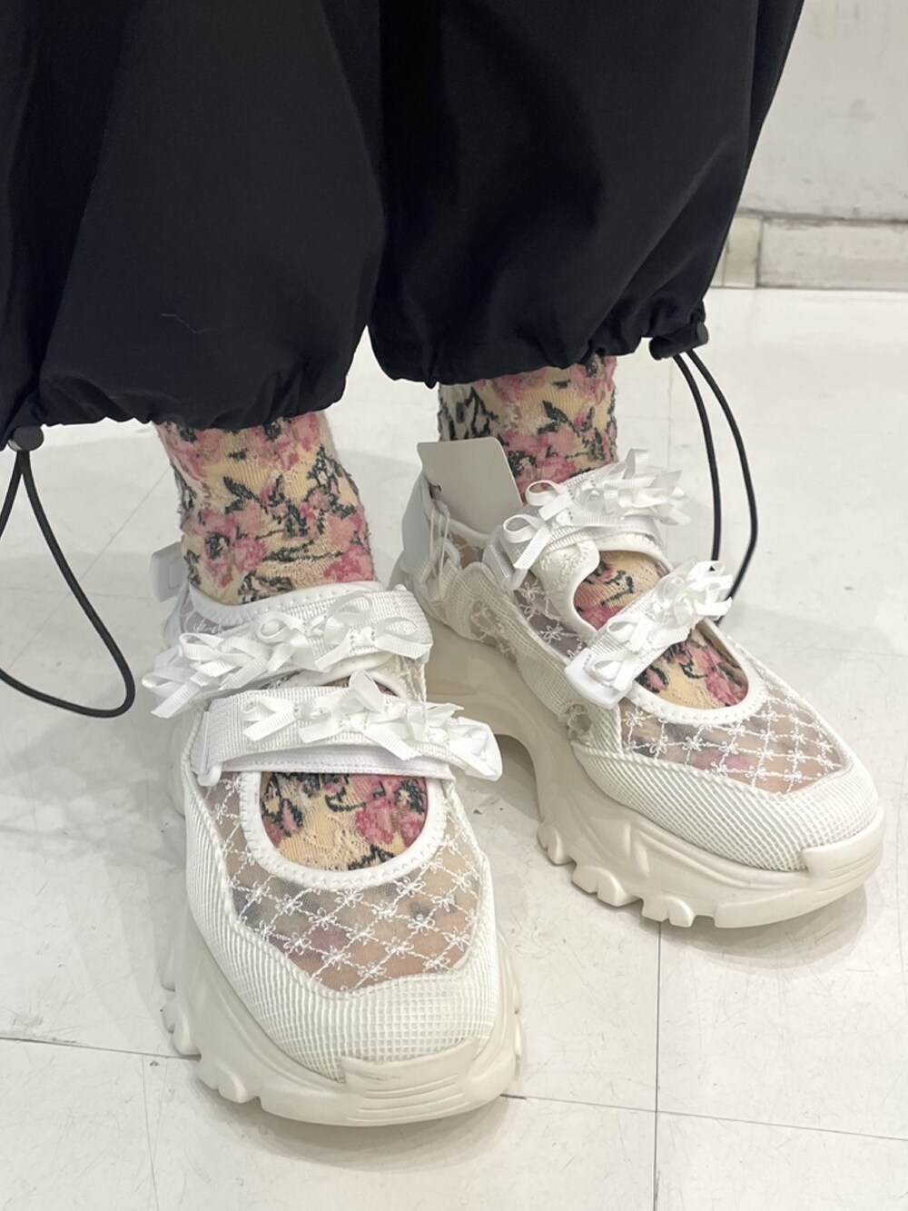 ブラック系のカーゴパンツ、ホワイト系のスニーカー、ホワイト系のTシャツ/カットソーを着用したレディースの冬コーディネートの6枚目の写真