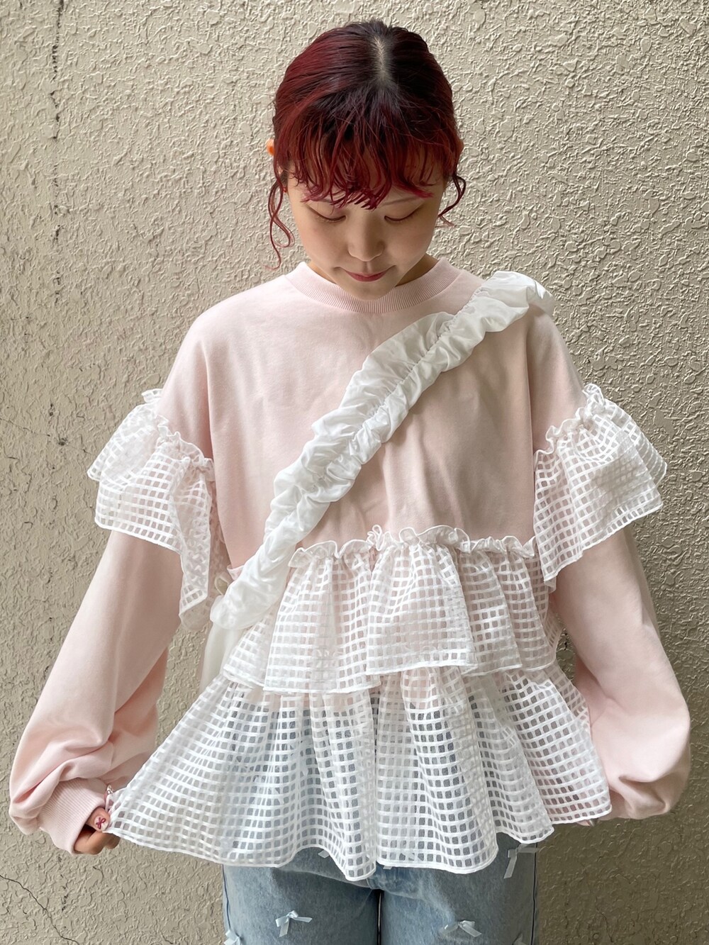 ブルー系のデニムパンツ、ピンク系のスウェット、ホワイト系のショルダーバッグを着用したレディースの冬コーディネートの4枚目の写真