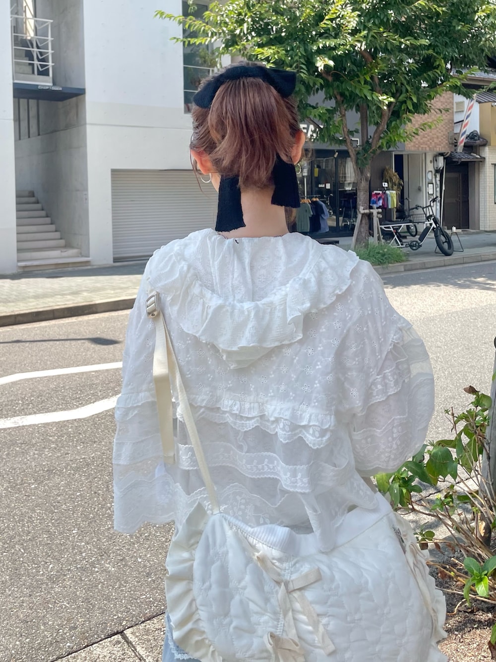 ホワイト系のシャツ/ブラウス、グリーン系のスニーカー、ブルー系のデニムパンツを着用したレディースの夏コーディネートの6枚目の写真