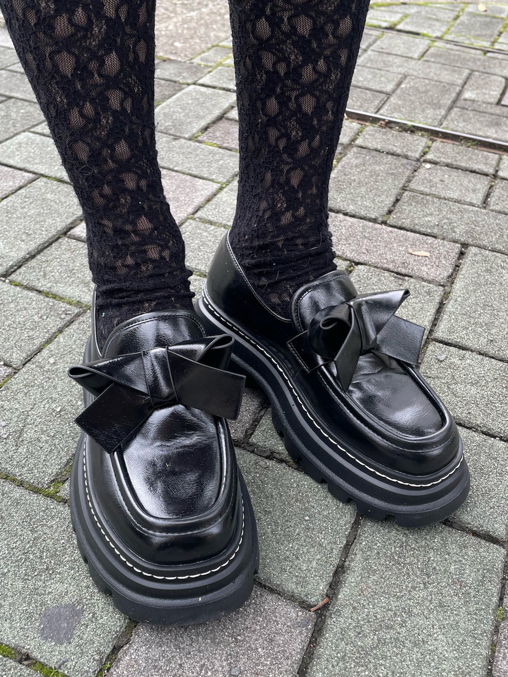 ブラック系のローファー、レッド系のニット/セーター、ブラック系のスカートを着用したレディースの秋コーディネートの5枚目の写真