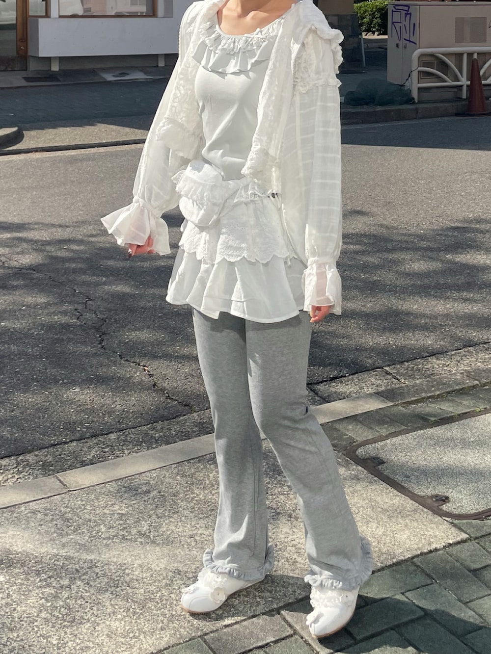 グレー系のスウェットパンツ、ホワイト系のブルゾン、グリーン系のTシャツ/カットソーを着用したレディースの春コーディネートの3枚目の写真