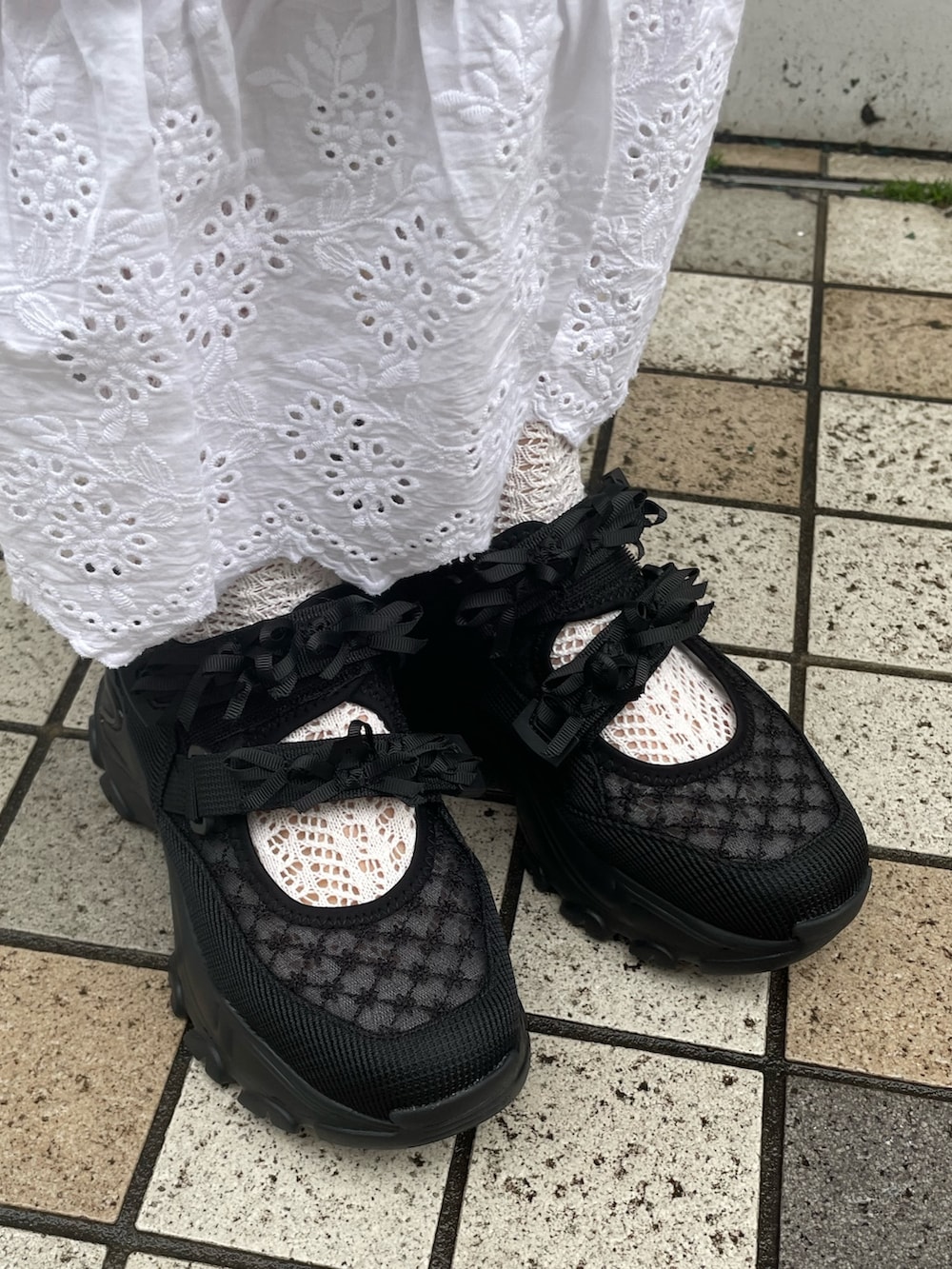 ブラック系のスニーカー、ブラック系のトートバッグ、グレー系のスウェットを着用したレディースの冬コーディネートの6枚目の写真