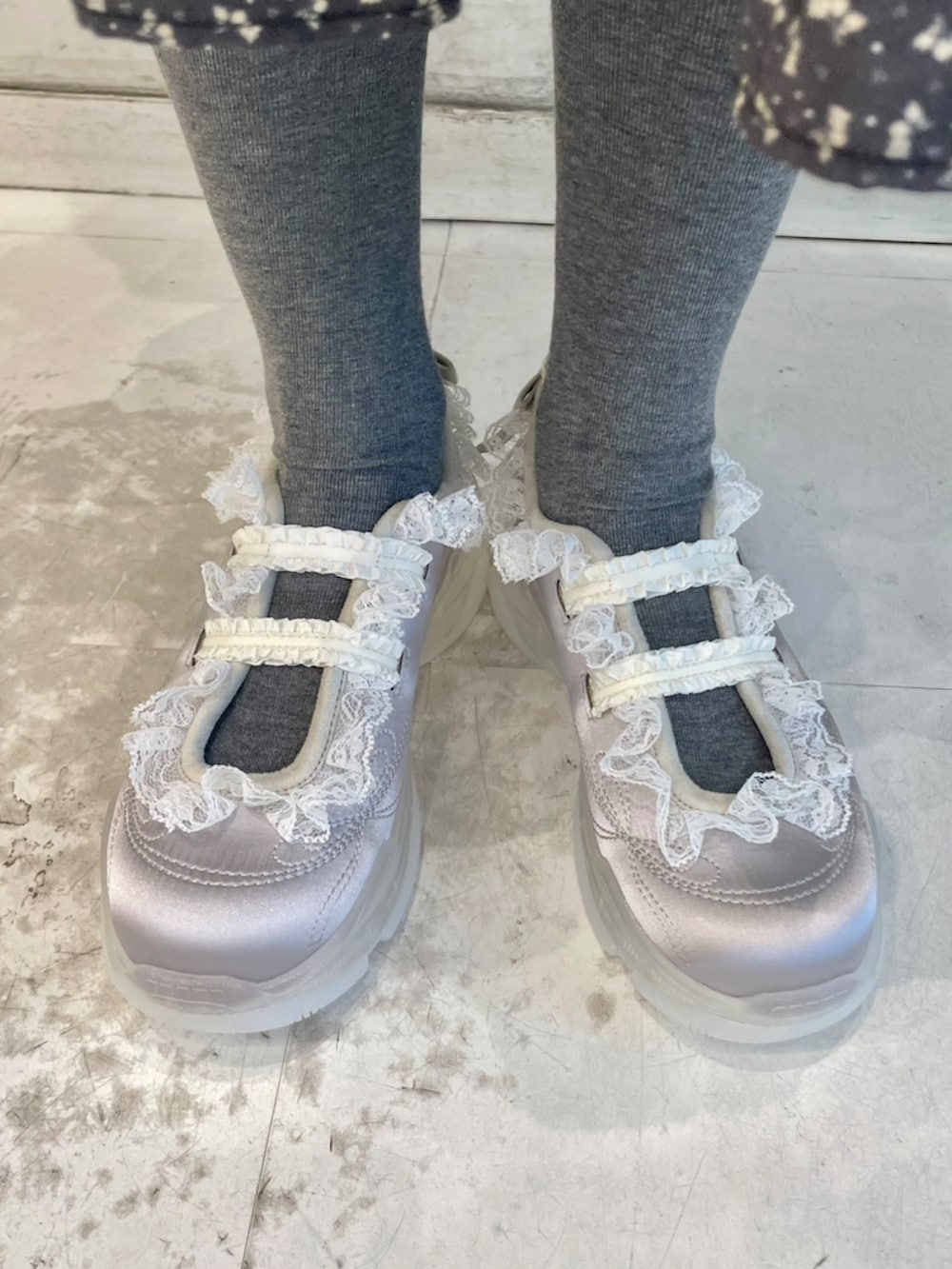 グレー系のパーカー、グレー系のメッセンジャーバッグ、ブラック系のワンピースを着用したレディースの冬コーディネートの9枚目の写真