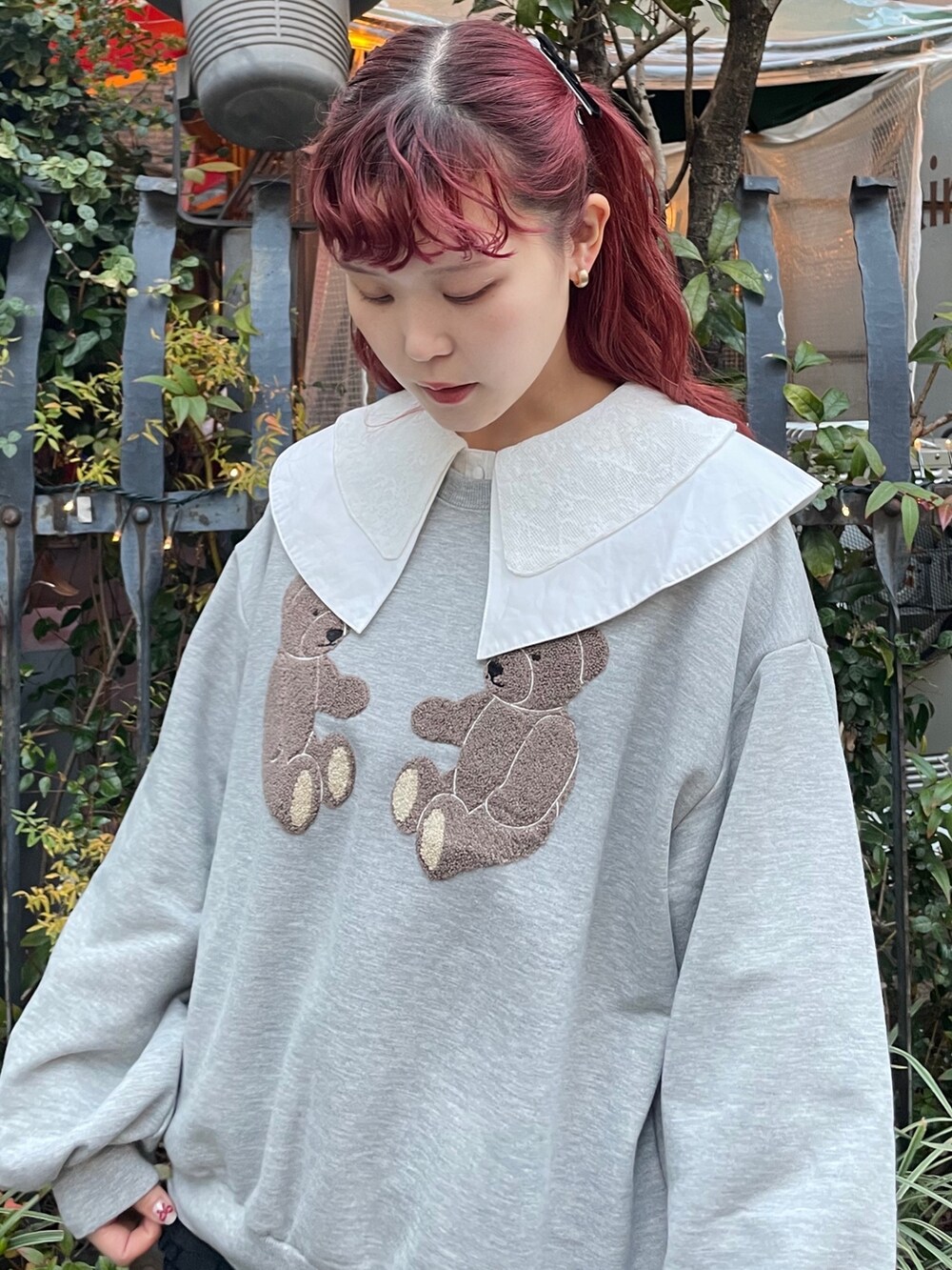 グレー系のスウェット、ブラック系のスカート、ブラック系のスニーカーを着用したレディースの冬コーディネートの4枚目の写真