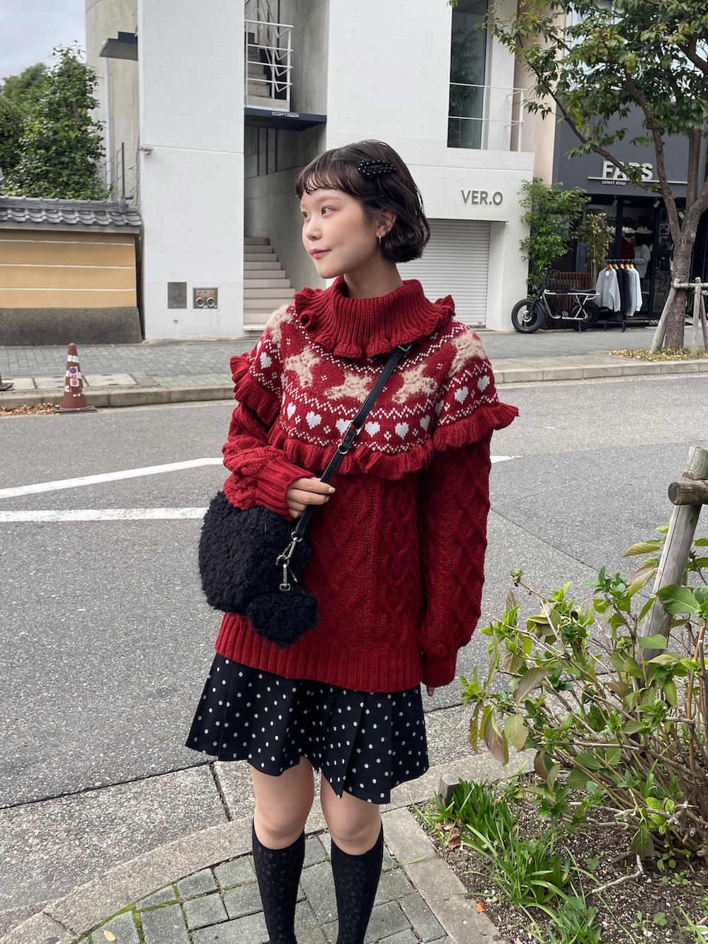 ブラック系のローファー、レッド系のニット/セーター、ブラック系のスカートを着用したレディースの秋コーディネートの3枚目の写真