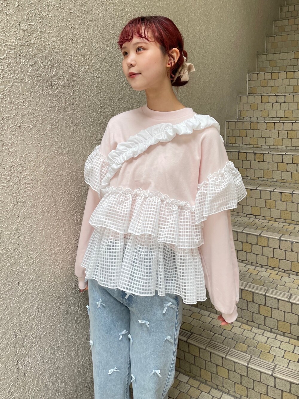 ブルー系のデニムパンツ、ピンク系のスウェット、ホワイト系のショルダーバッグを着用したレディースの冬コーディネートの5枚目の写真