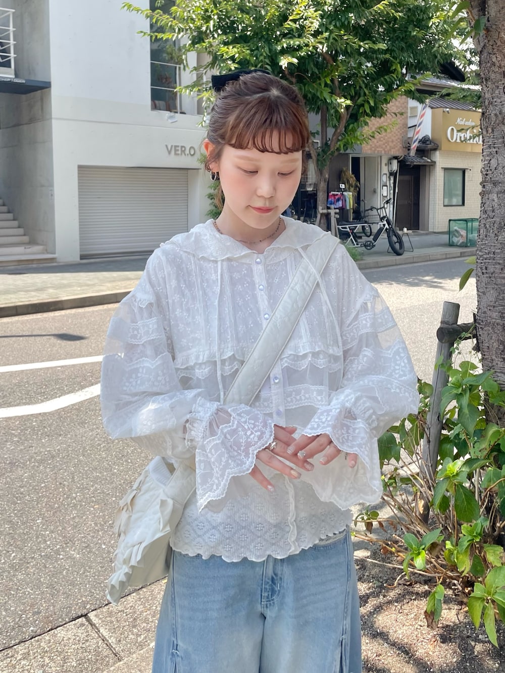 ホワイト系のシャツ/ブラウス、グリーン系のスニーカー、ブルー系のデニムパンツを着用したレディースの夏コーディネートの5枚目の写真