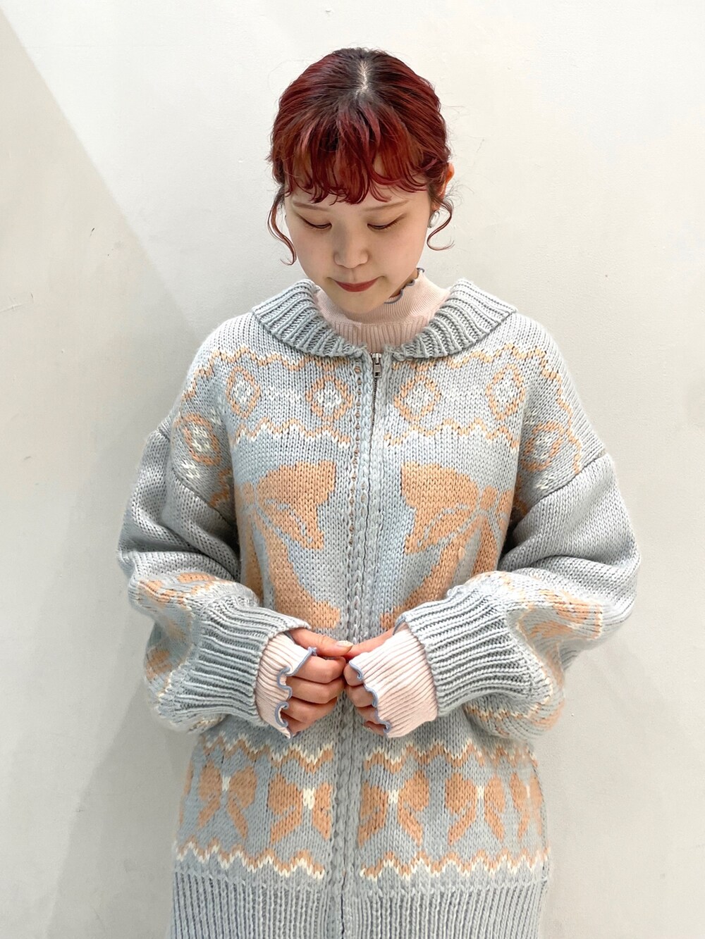 ホワイト系のスカート、ホワイト系のスニーカー、ブルー系のカーディガン/ボレロを着用したレディースの秋コーディネートの3枚目の写真