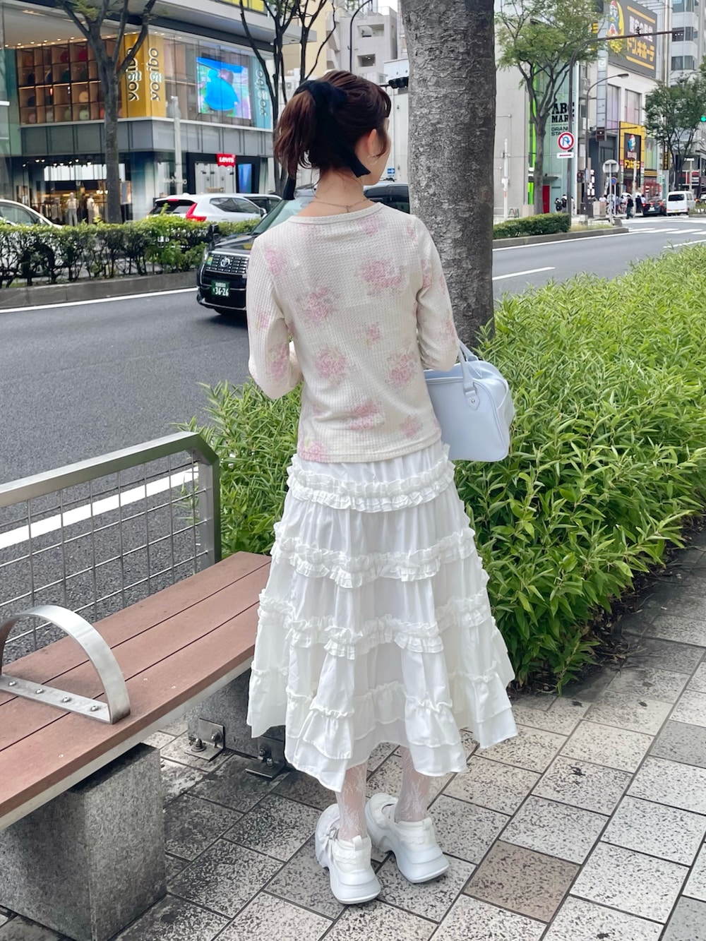 ピンク系のTシャツ/カットソー、ホワイト系のスカート、ブルー系のハンドバッグを着用したレディースの秋コーディネートの2枚目の写真