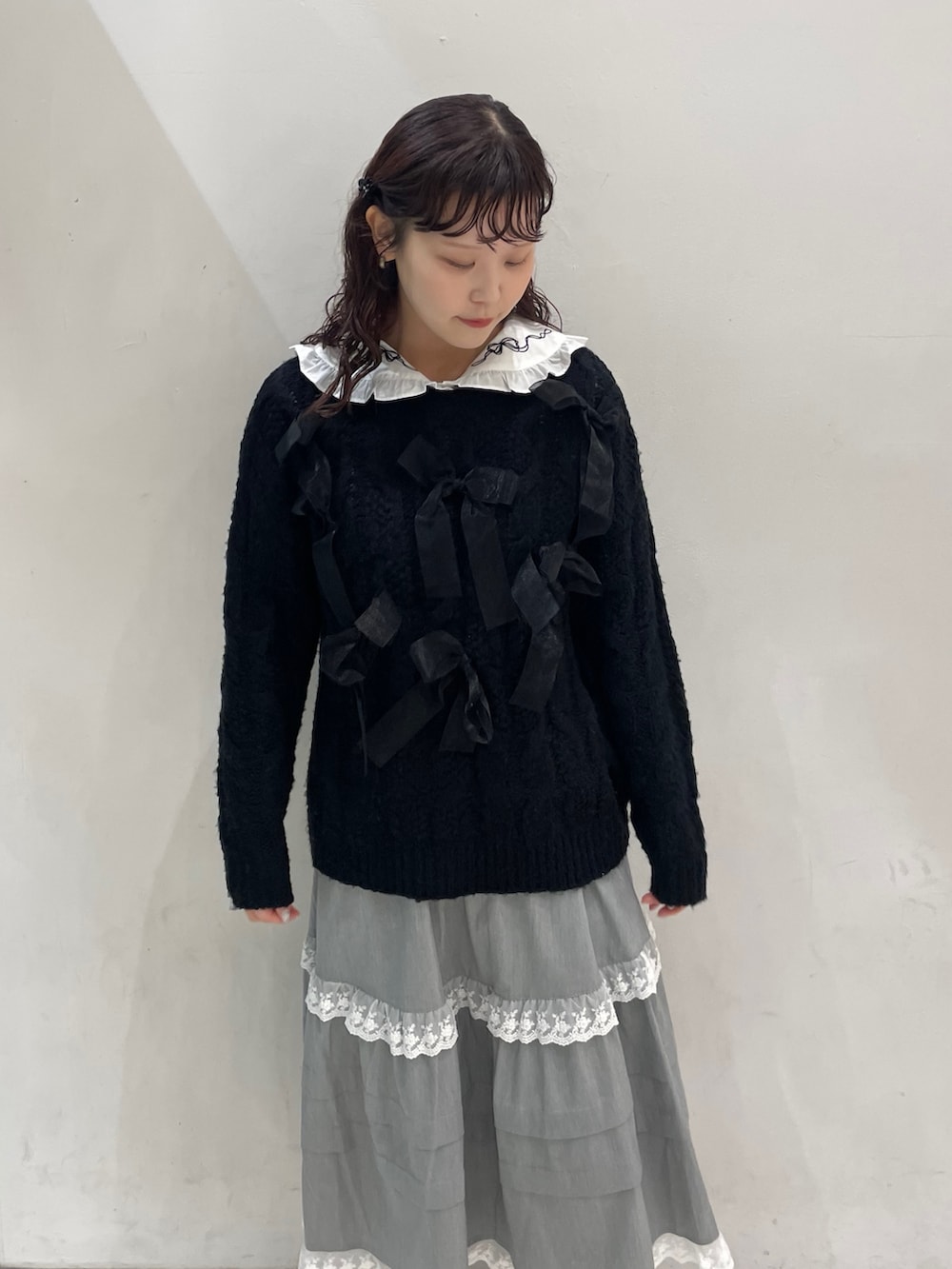 グレー系のスカート、ブラック系のダウンジャケット/コート、ブラック系のニット/セーターを着用したレディースの冬コーディネートの5枚目の写真