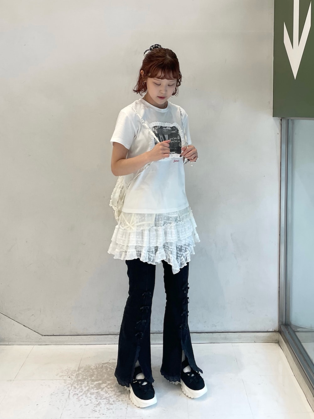 ホワイト系のスカート、ブラック系のデニムパンツ、ホワイト系のTシャツ/カットソーを着用したレディースの夏コーディネートの2枚目の写真