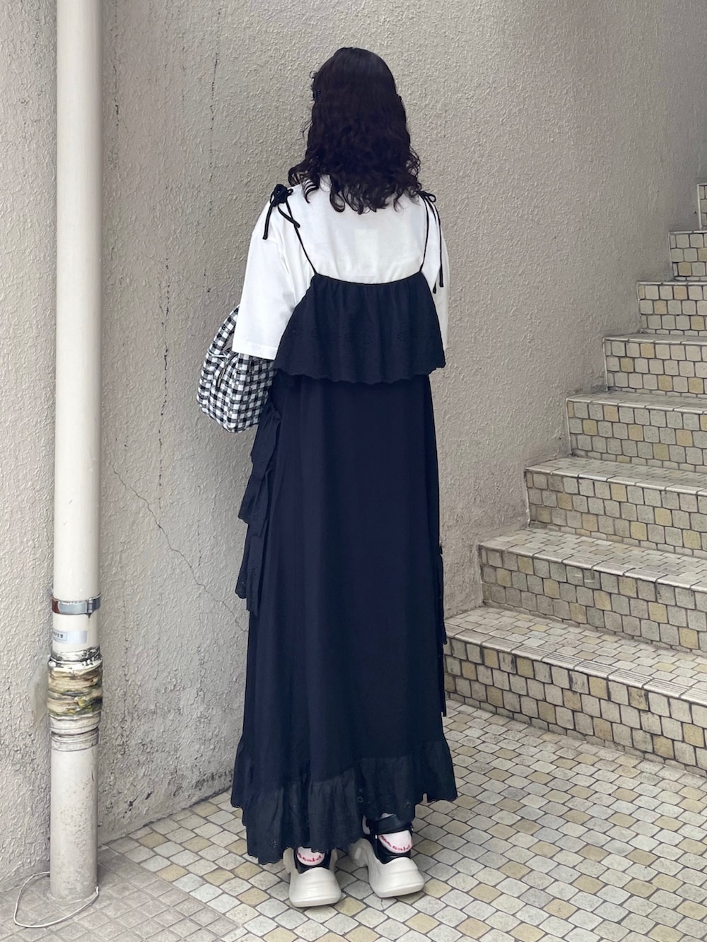 ブラック系のワンピース、ホワイト系のTシャツ/カットソー、ブラック系のサンダルを着用したレディースの夏コーディネートの3枚目の写真