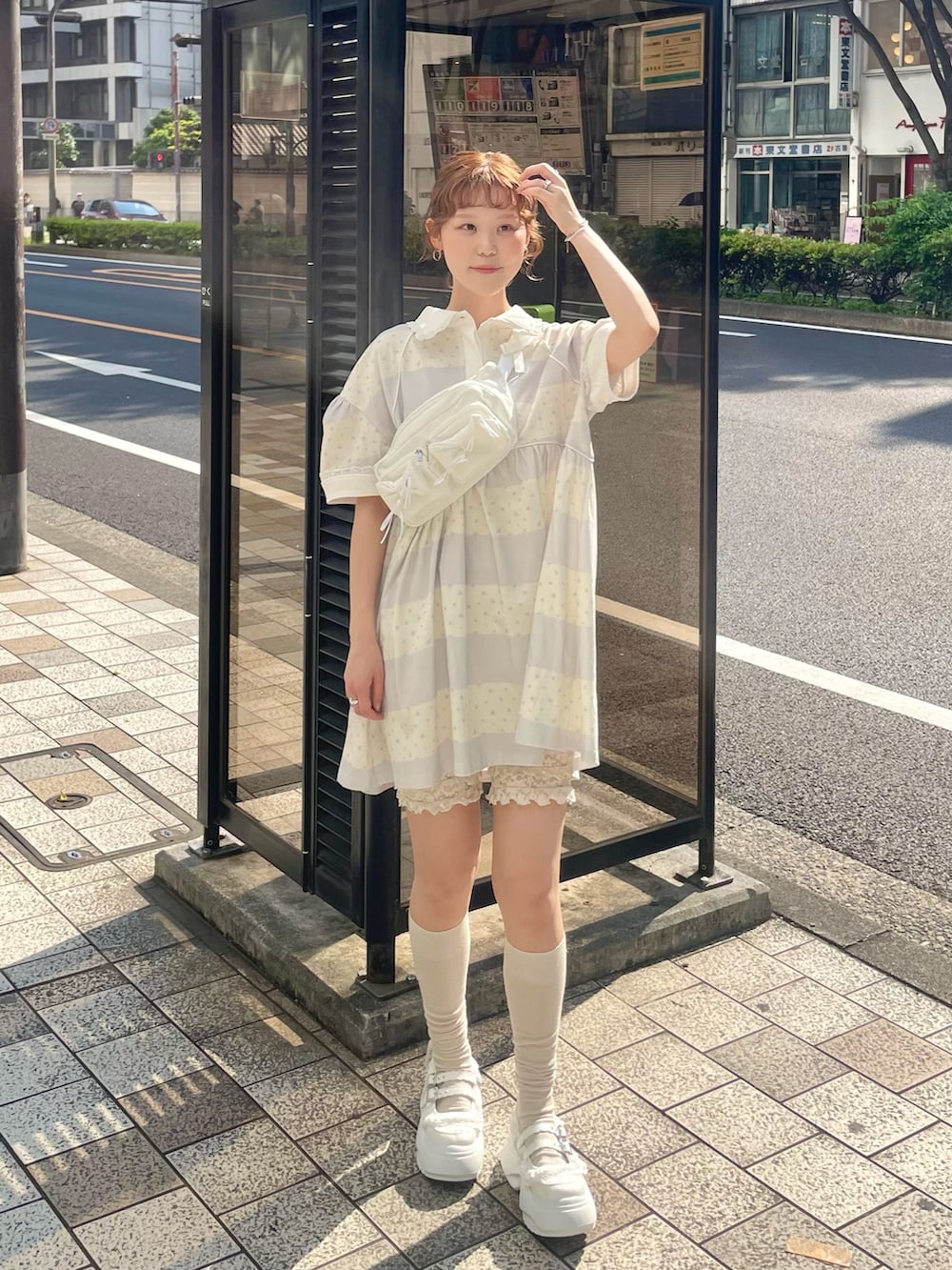 パープル系のワンピース、ホワイト系のスニーカー、ホワイト系のボディバッグ/ウエストポーチを着用したレディースの春コーディネートの3枚目の写真