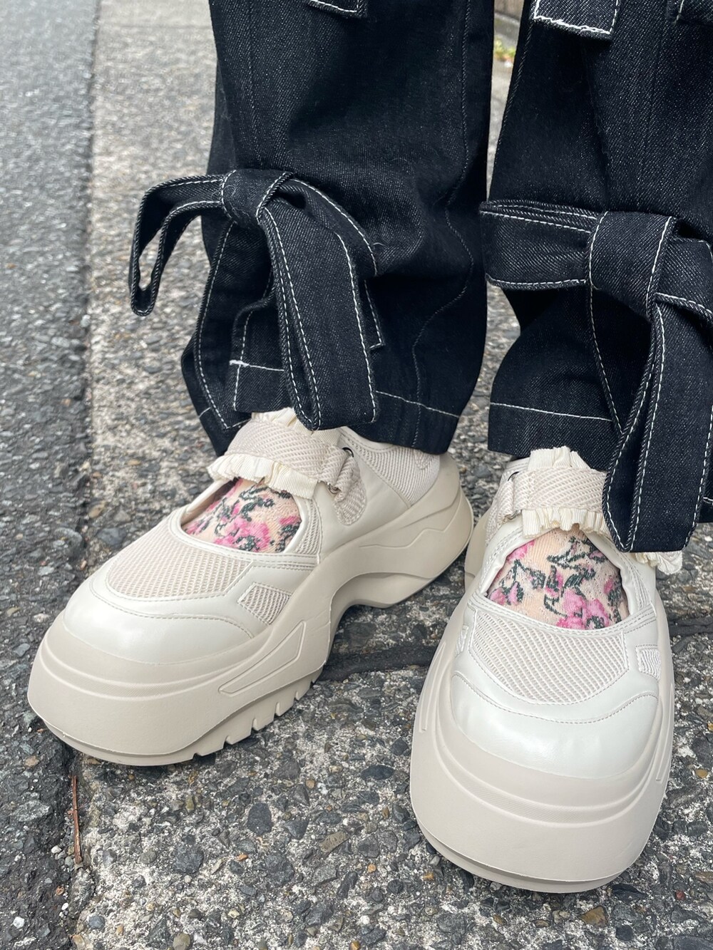 ブラック系のデニムパンツ、ホワイト系のスニーカー、ホワイト系のスウェットを着用したレディースの冬コーディネートの5枚目の写真