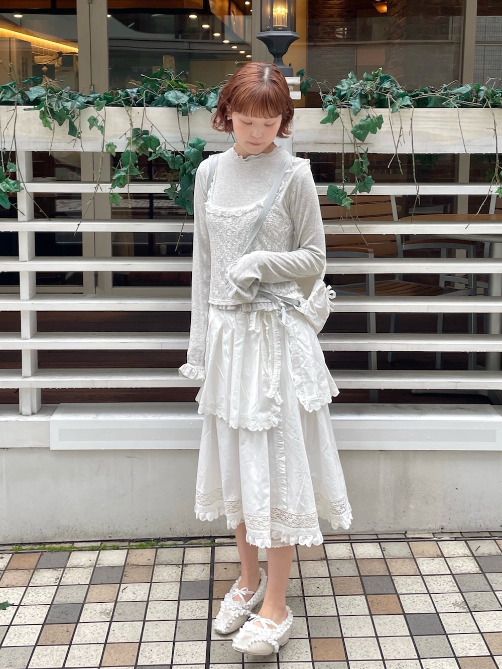 ホワイト系のスカート、ホワイト系のバレエシューズ、グレー系のTシャツ/カットソーを着用したレディースの冬コーディネートの2枚目の写真