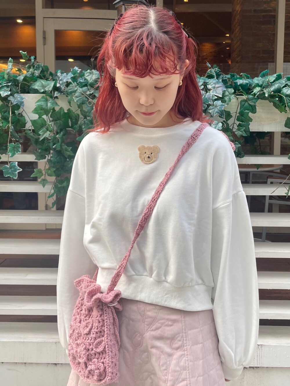 ピンク系のスカート、ホワイト系のスニーカー、ホワイト系のスウェットを着用したレディースの冬コーディネートの4枚目の写真