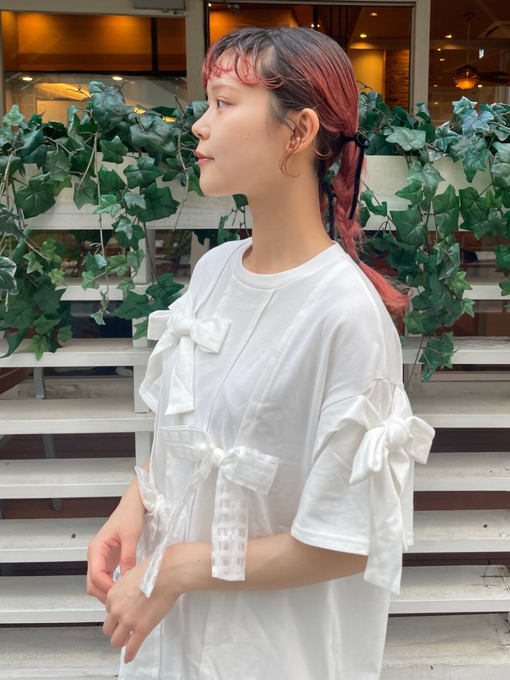 ホワイト系のTシャツ/カットソー、ホワイト系のスカート、ブラック系のスニーカーを着用したレディースの春コーディネートの3枚目の写真