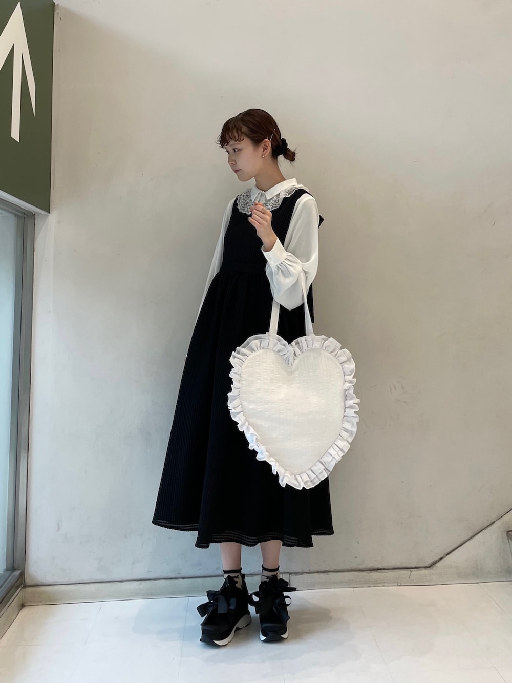 ブラック系のワンピース、ホワイト系のトートバッグ、ブラック系のスニーカーを着用したレディースの春コーディネートの3枚目の写真