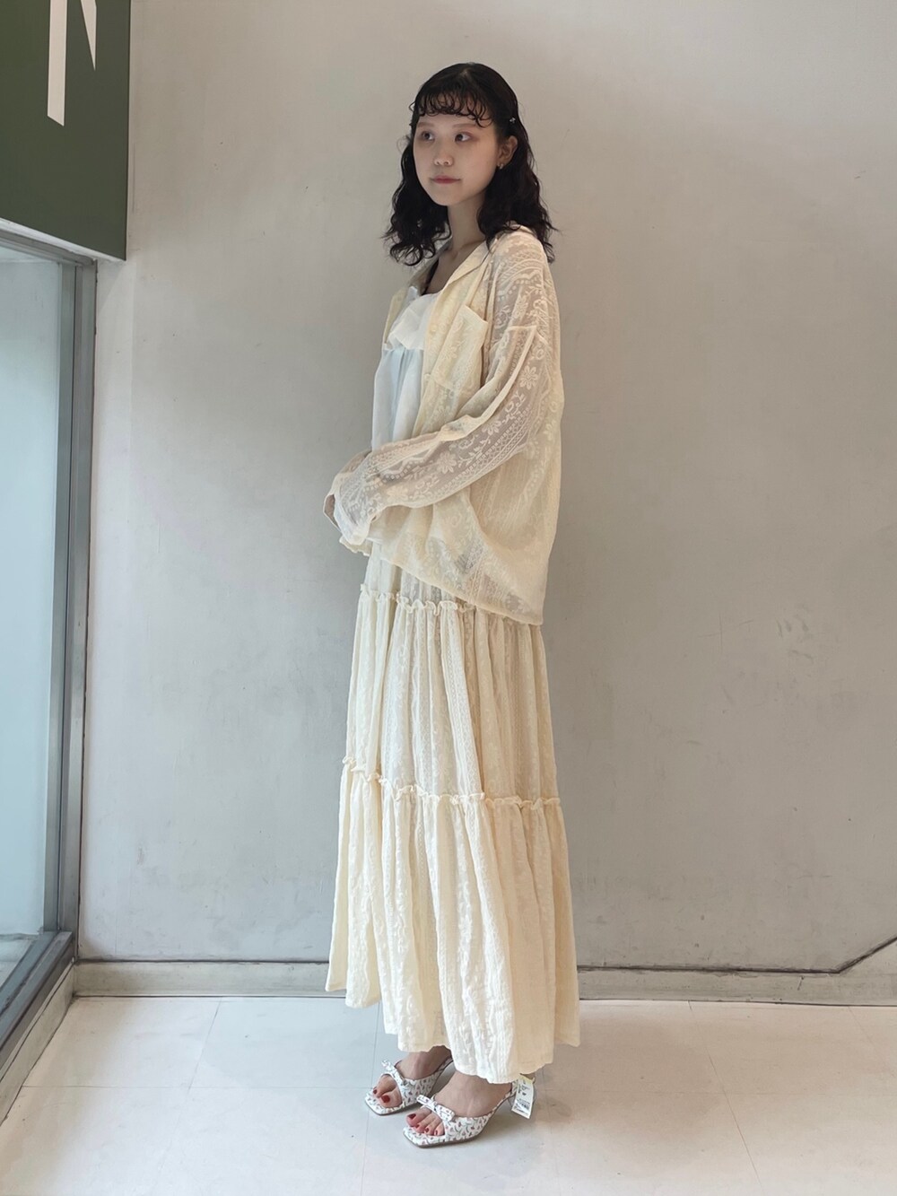 ホワイト系のスカート、ホワイト系のパンプス、ホワイト系のキャミソールを着用したレディースの夏コーディネートの2枚目の写真