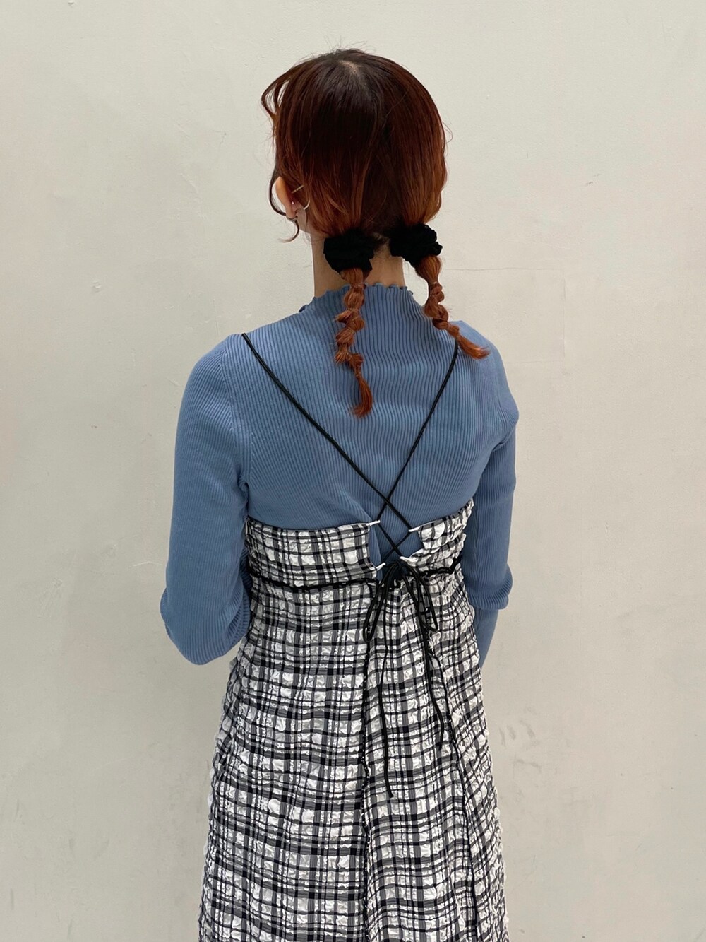 ホワイト系のスラックス、ブルー系のニット/セーター、ブラック系のワンピースを着用したレディースの冬コーディネートの5枚目の写真