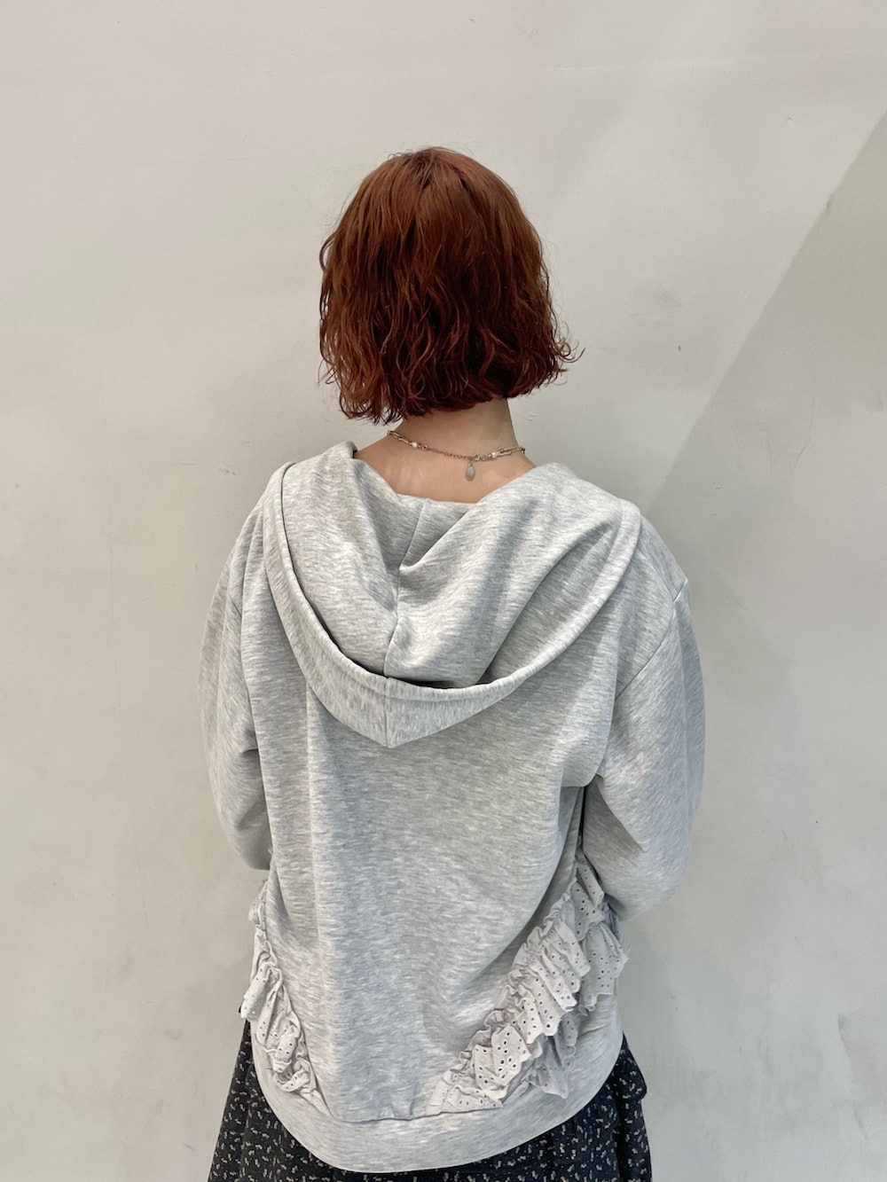 グレー系のパーカー、グレー系のメッセンジャーバッグ、ブラック系のワンピースを着用したレディースの冬コーディネートの6枚目の写真